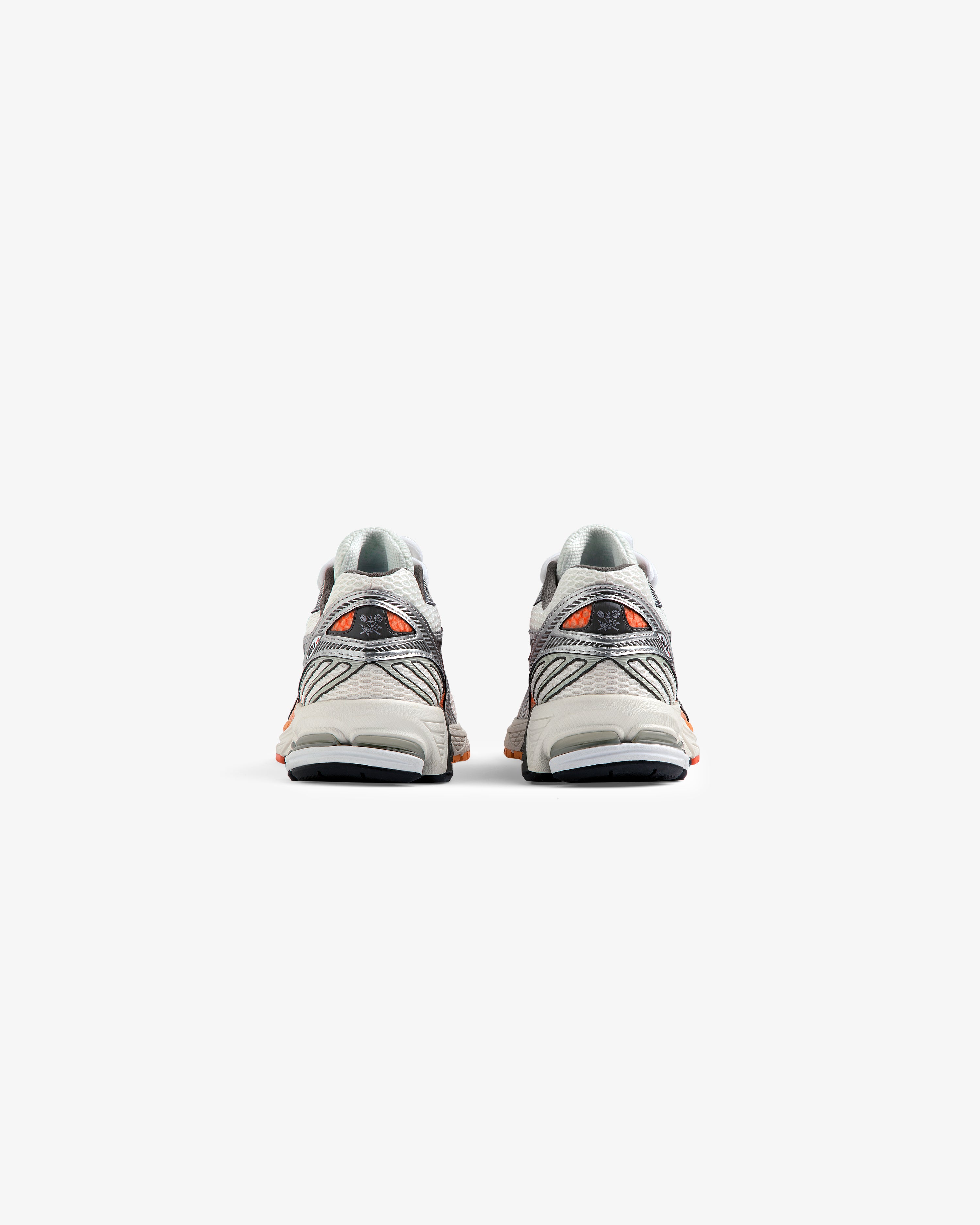 A pair of ALD / New Balance 860v2 gray and orange sneakers shown from the back on a white background.
