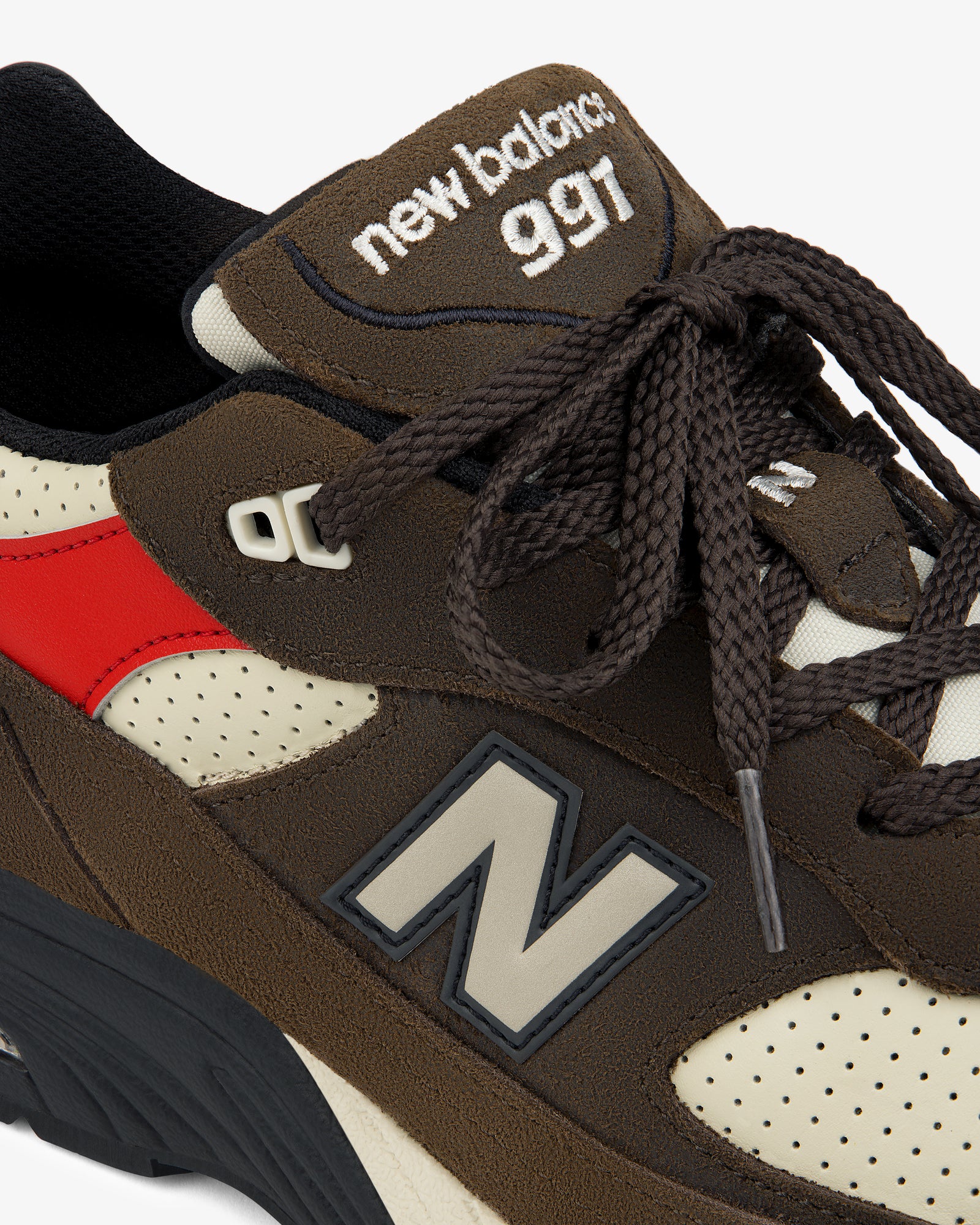 Close-up of a brown ALD / New Balance Made in UK 991 sneaker with red accent and visible logo on side and tongue.