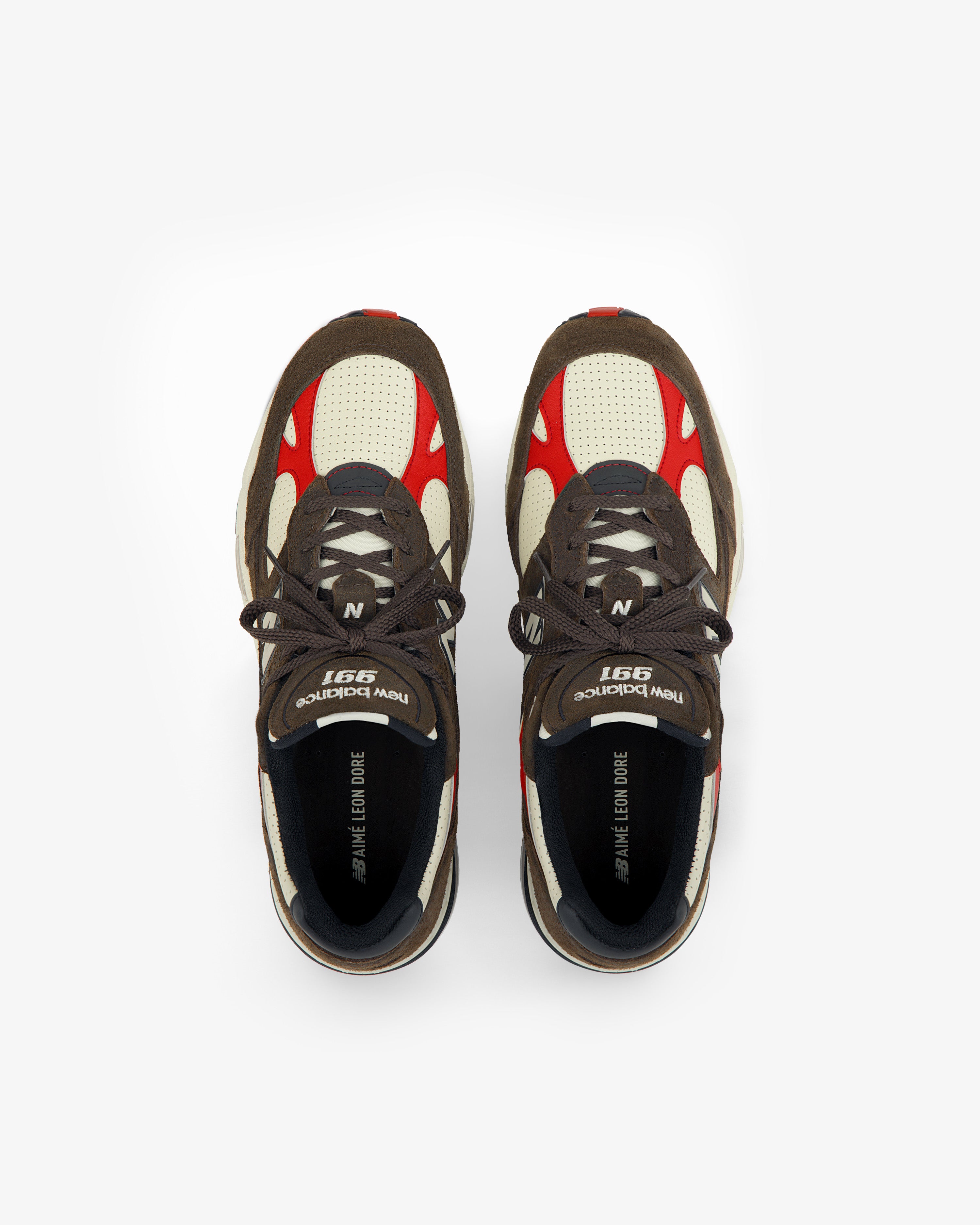 A pair of brown, cream, and red ALD / New Balance Made in UK 991 sneakers viewed from above on a white background.