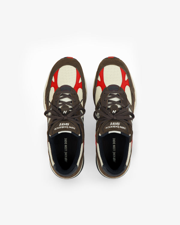 A pair of brown, cream, and red ALD / New Balance Made in UK 991 sneakers viewed from above on a white background.