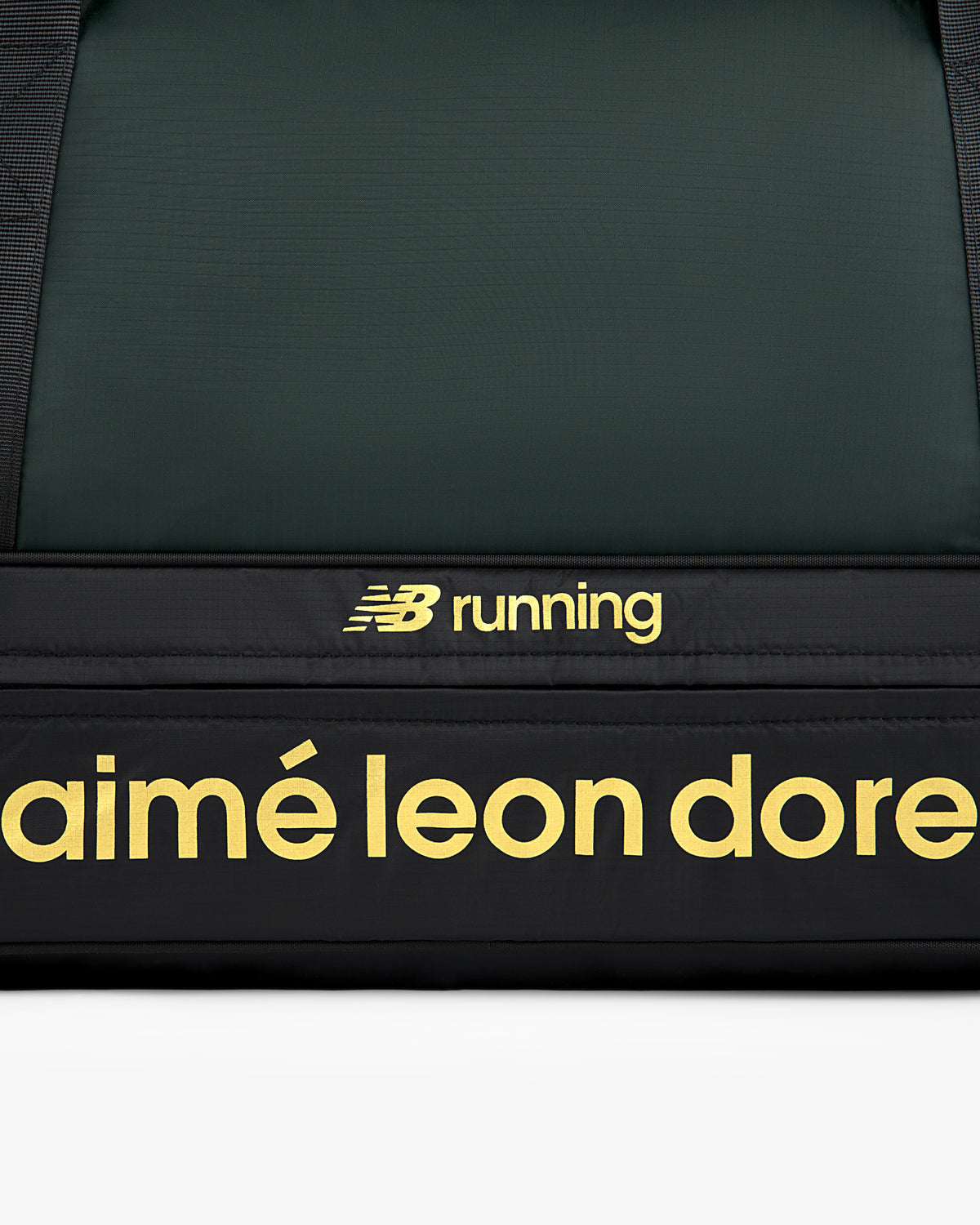 Close-up of the ALD / New Balance Travel Duffle Bag featuring yellow logos on a black background.