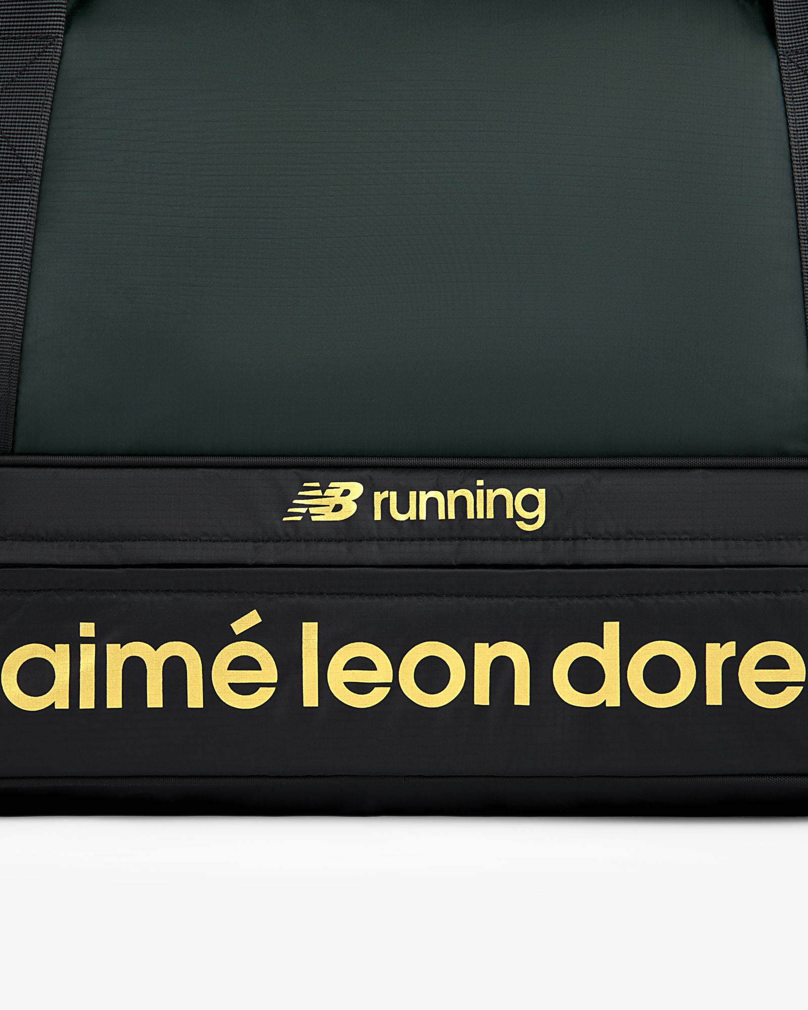 Close-up of the ALD / New Balance Travel Duffle Bag featuring yellow logos on a black background.