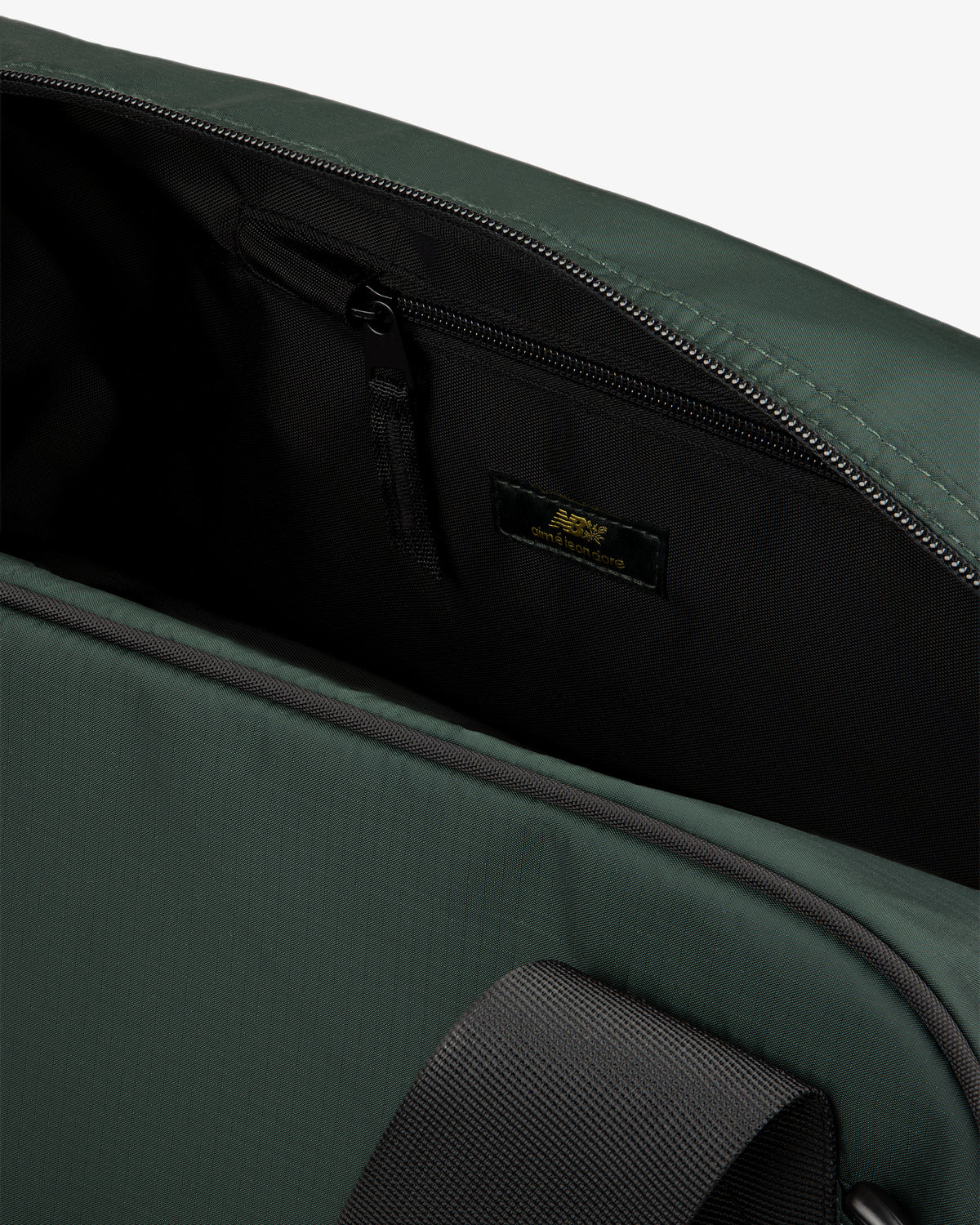 Close-up of ALD / New Balance Travel Duffle Bag open, showing black zippered inner pocket and inside label.