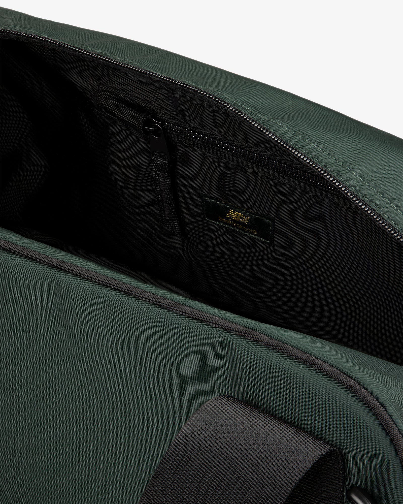 Close-up of ALD / New Balance Travel Duffle Bag open, showing black zippered inner pocket and inside label.