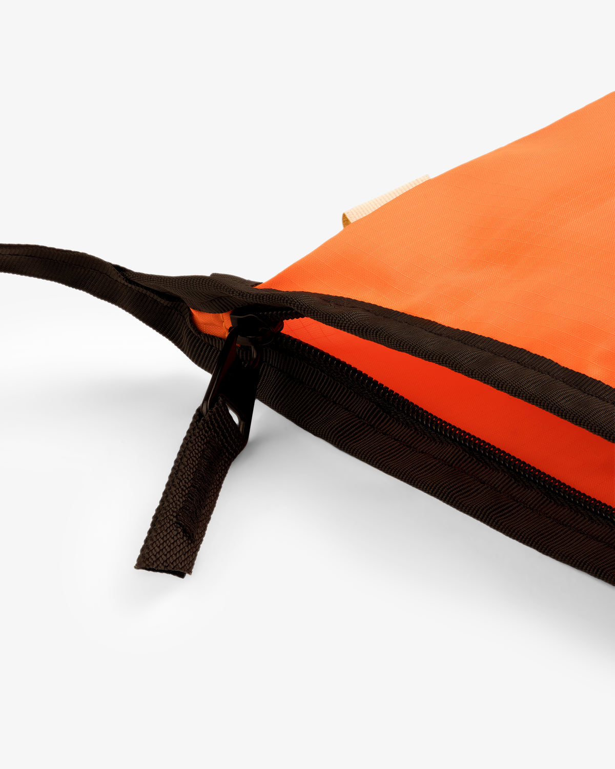 Close-up of the ALD / New Balance Nylon Sling Pouch in orange with a black zipper, partially open on a white background.