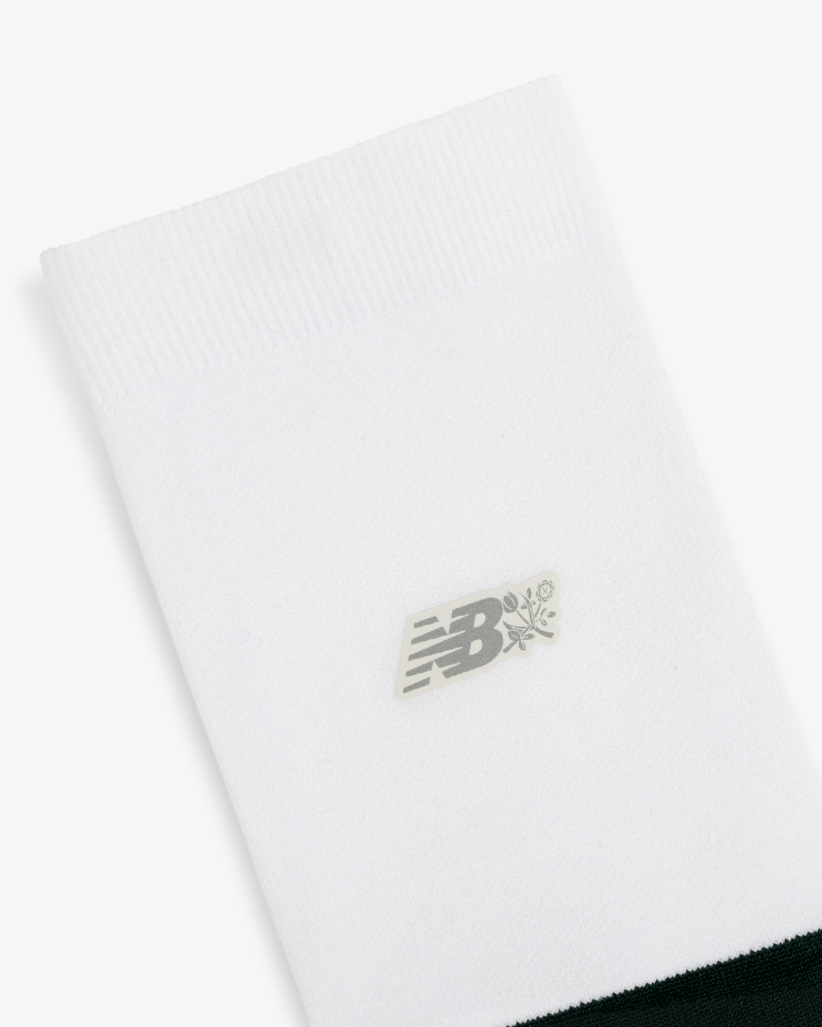 ALD / New Balance Running Crew Sock: white with ribbed top, small gray NB logo, and flower graphic at center.