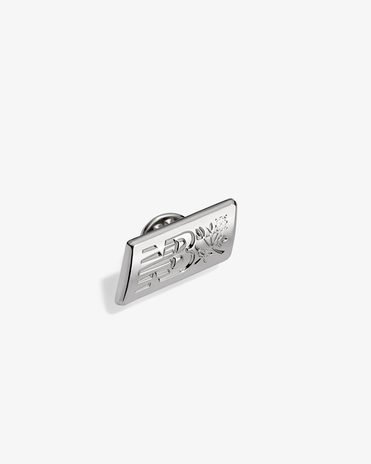 ALD / New Balance Logo Pin, rectangular silver with engraved design, shown on a plain white background.