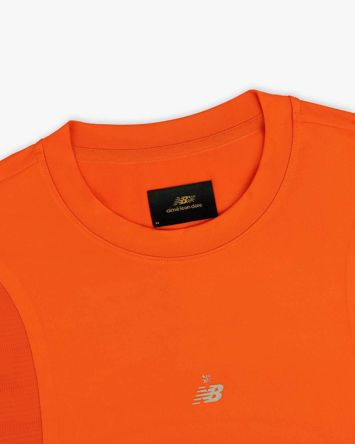 Close-up of an orange ALD / New Balance Performance Long-Sleeve Tee with crew neck and black label inside the collar.
