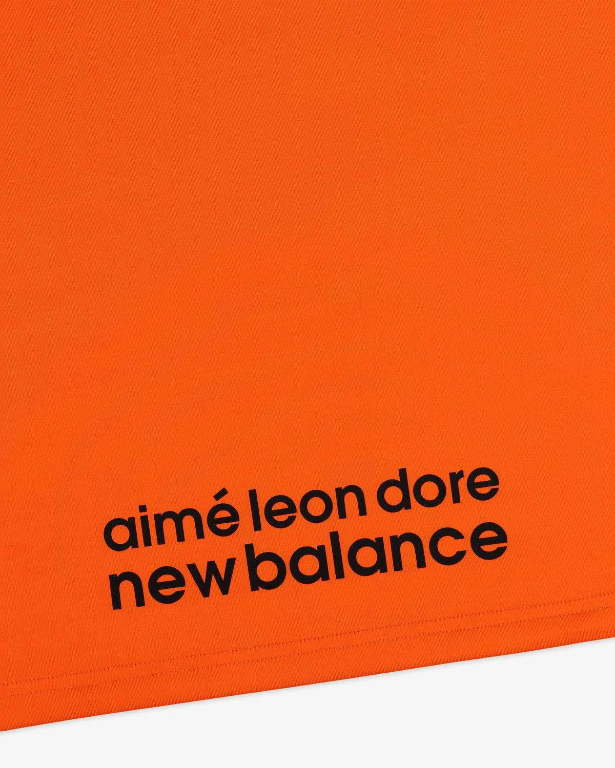 Bright orange ALD / New Balance Performance Long-Sleeve Tee with bold black logo near the bottom edge.