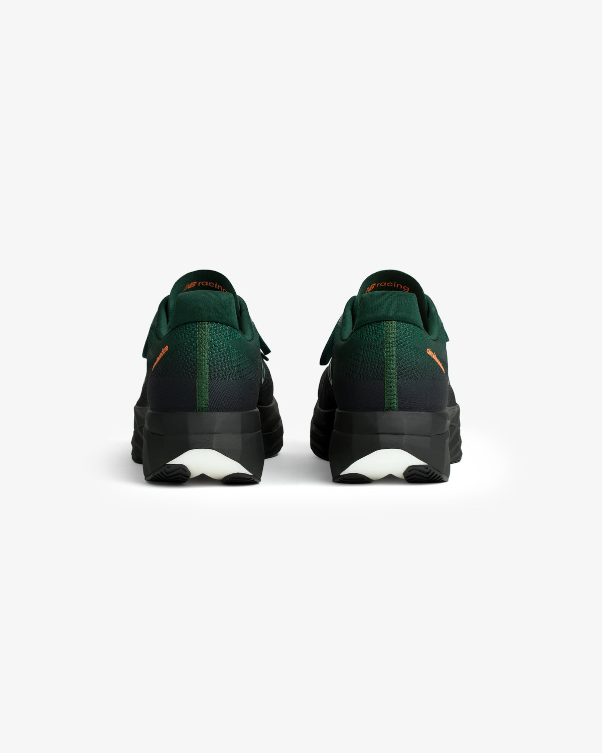 A pair of ALD / New Balance FuelCell SuperComp Elite v5 shoes in green and black, viewed from the back on white.