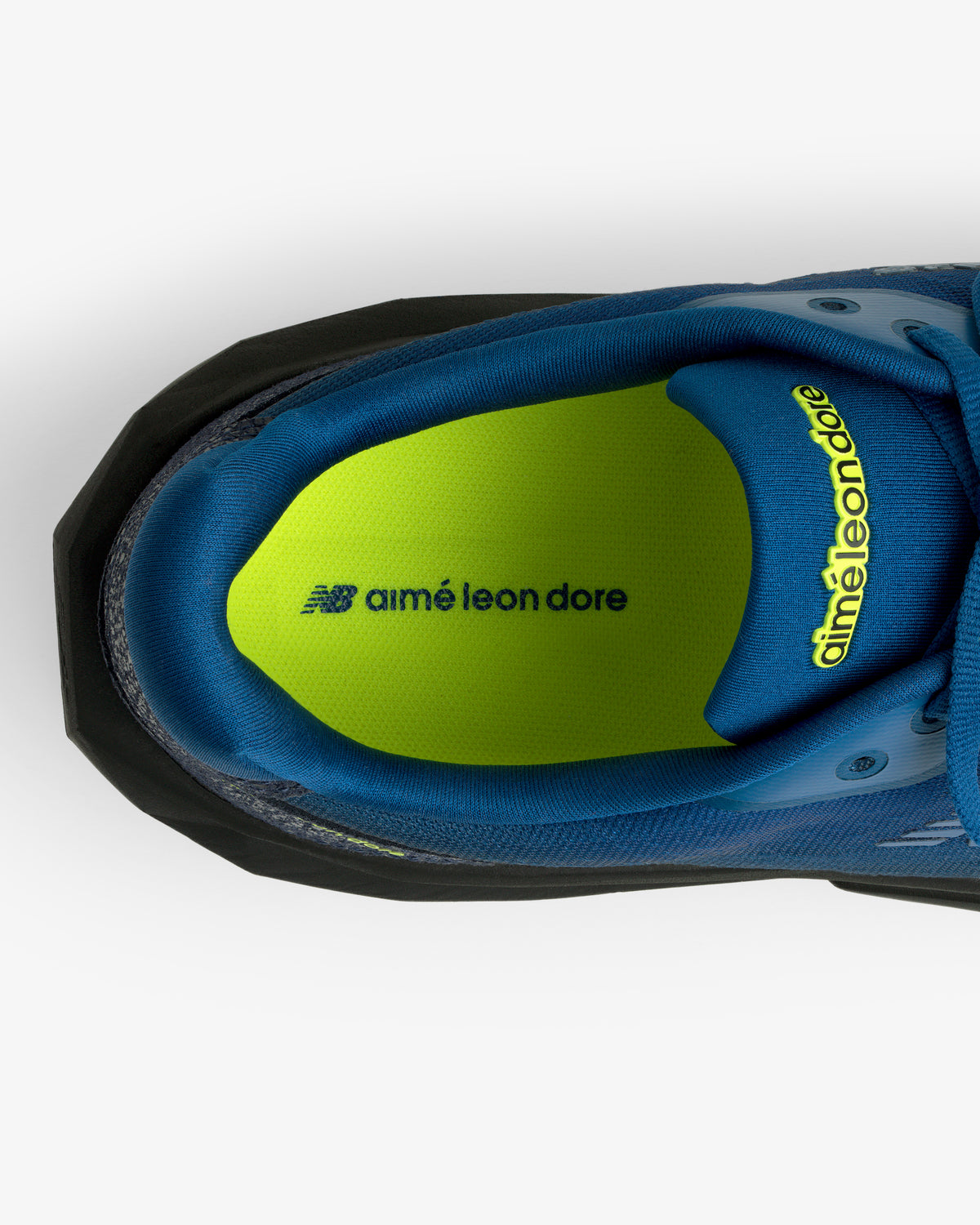 Top view of the ALD / New Balance FuelCell Rebel v5, blue with a green insole showing aimé leon dore and NB logos.