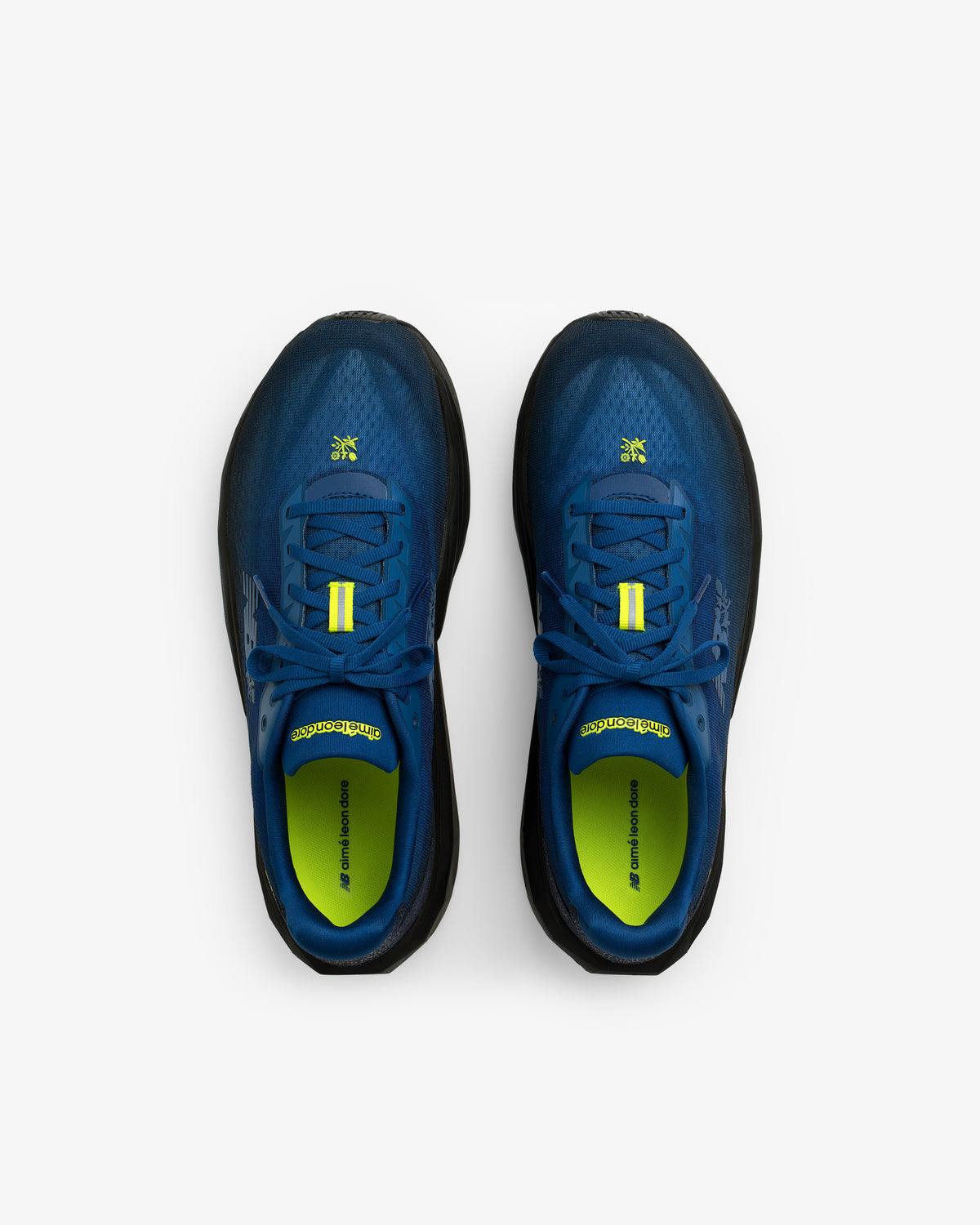 ALD / New Balance FuelCell Rebel v5 running shoes in blue and black with yellow accents, top view on white background.