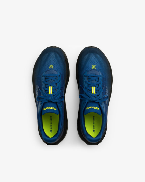 ALD / New Balance FuelCell Rebel v5 running shoes in blue and black with yellow accents, top view on white background.