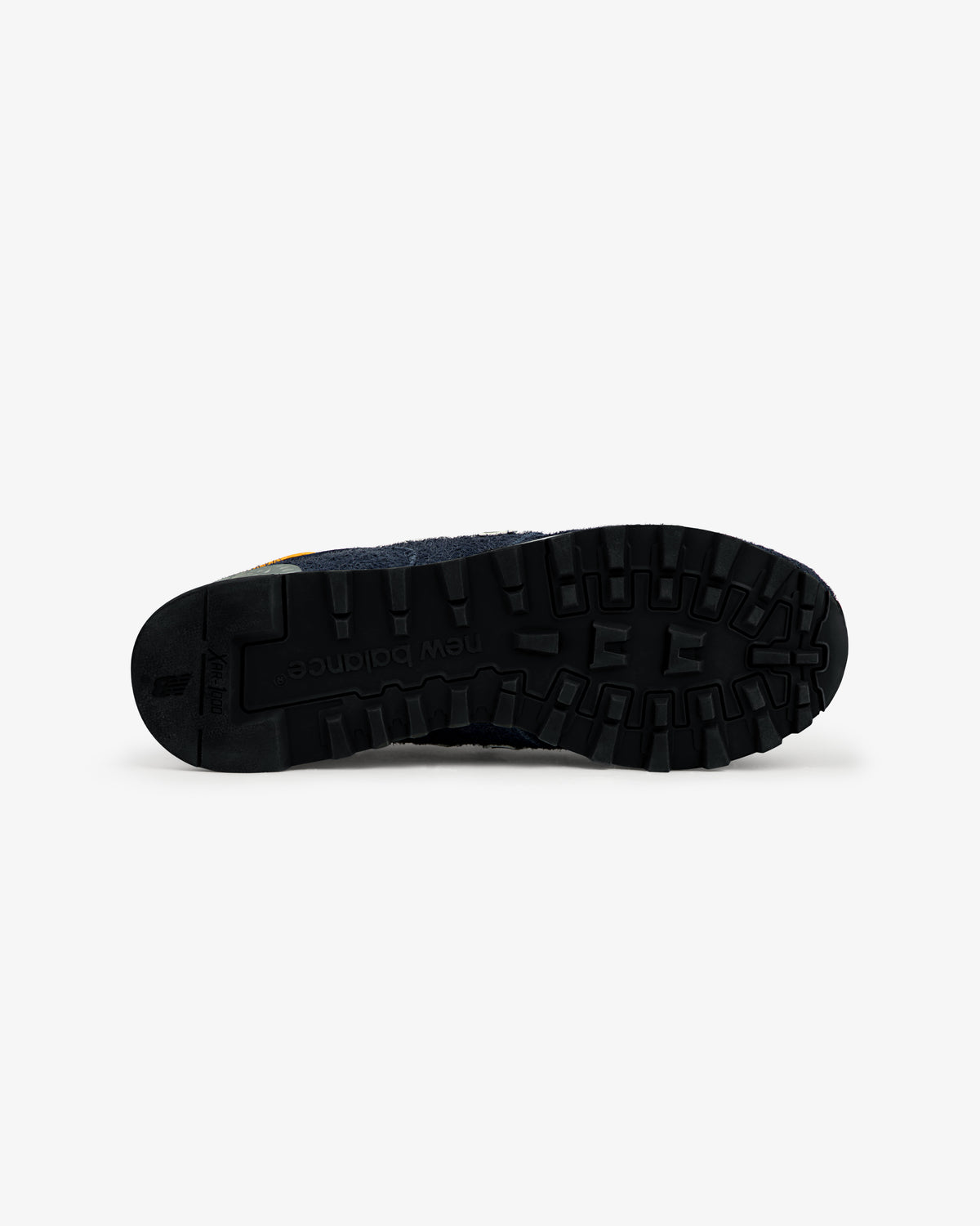 The black rubber sole of the ALD / New Balance Made in USA 1300 sneaker is shown from the bottom on a white background.