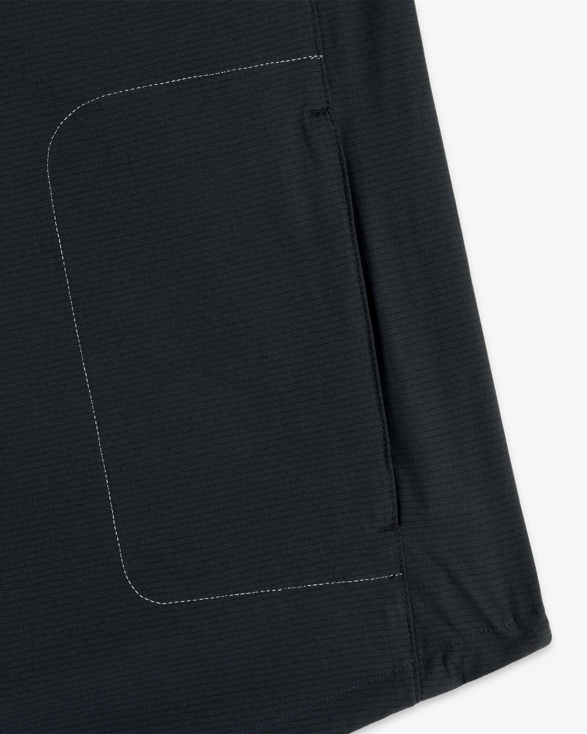 Close-up of the ALD / New Balance Performance Nylon Jacket’s dark fabric pocket with white side stitching.