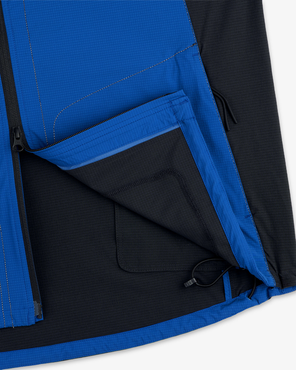 Close-up of the inside pocket and hem drawcord on the ALD / New Balance Performance Nylon Jacket in blue and black.
