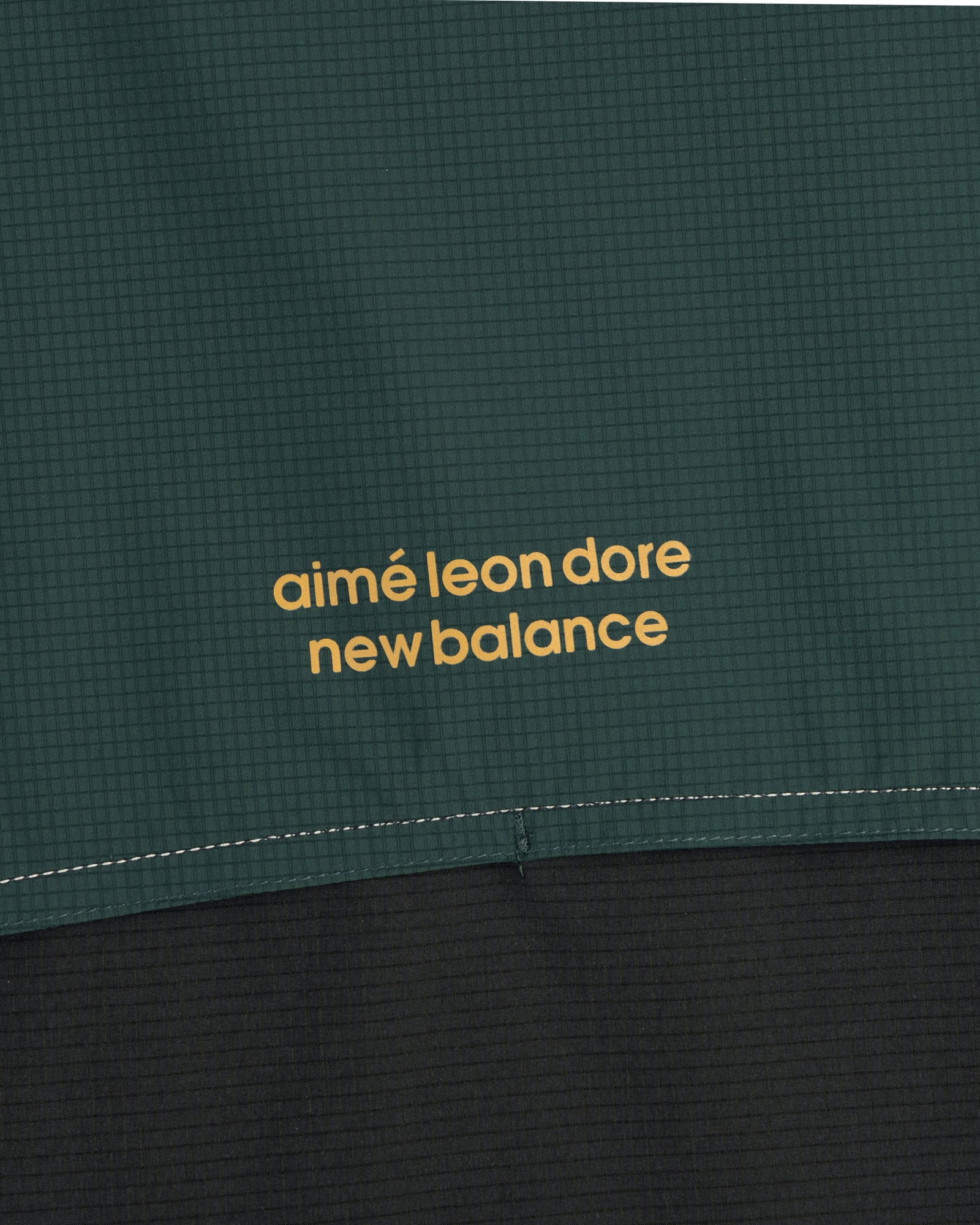 Close-up of the ALD / New Balance Performance Nylon Jacket in green and black with yellow branding.