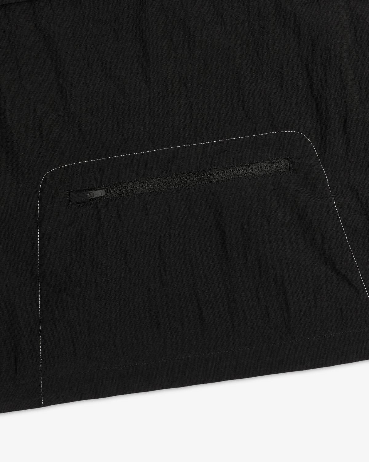 Close-up of the ALD / New Balance Breathable Half-Zip Pullover with a zip pocket and white stitching detail.