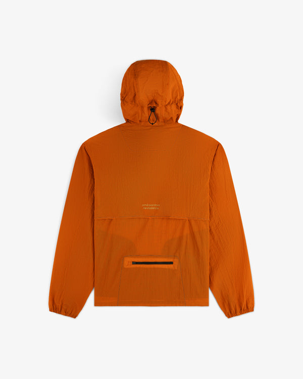 Back view of ALD / New Balance Breathable Half-Zip Pullover in orange, with center pocket and elastic cuffs on white.