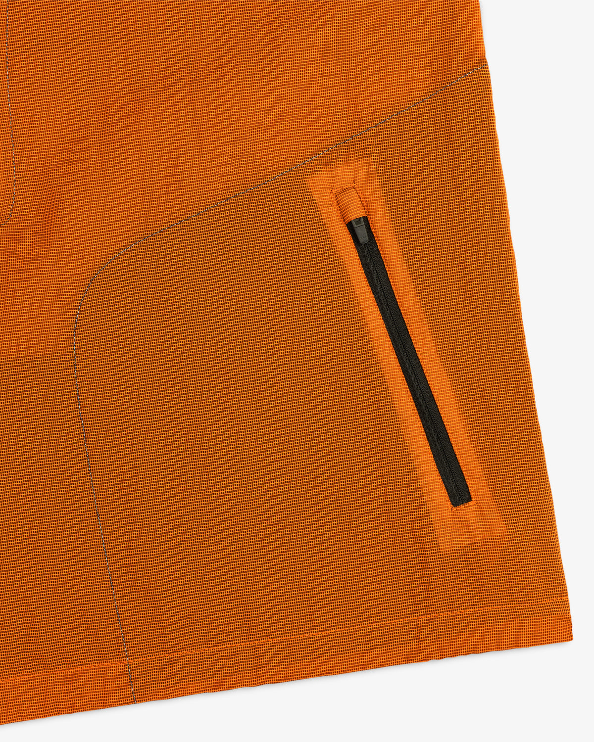 Close-up of the ALD / New Balance Breathable Half-Zip Pullover’s orange fabric, black zipper pocket, and detailed stitching.