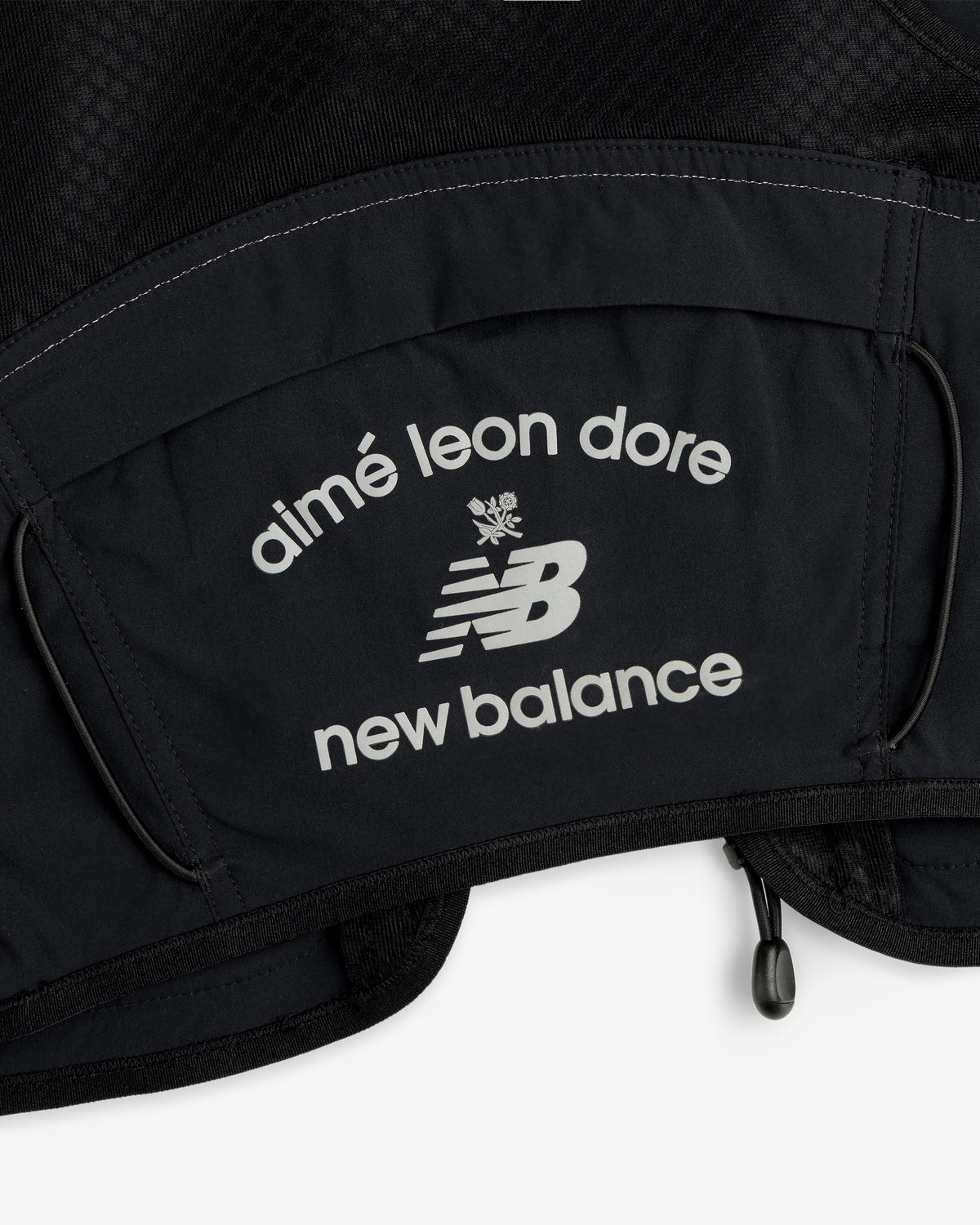 Close-up of the ALD / New Balance Hydrovest's black fabric with white aimé leon dore and NB logos.