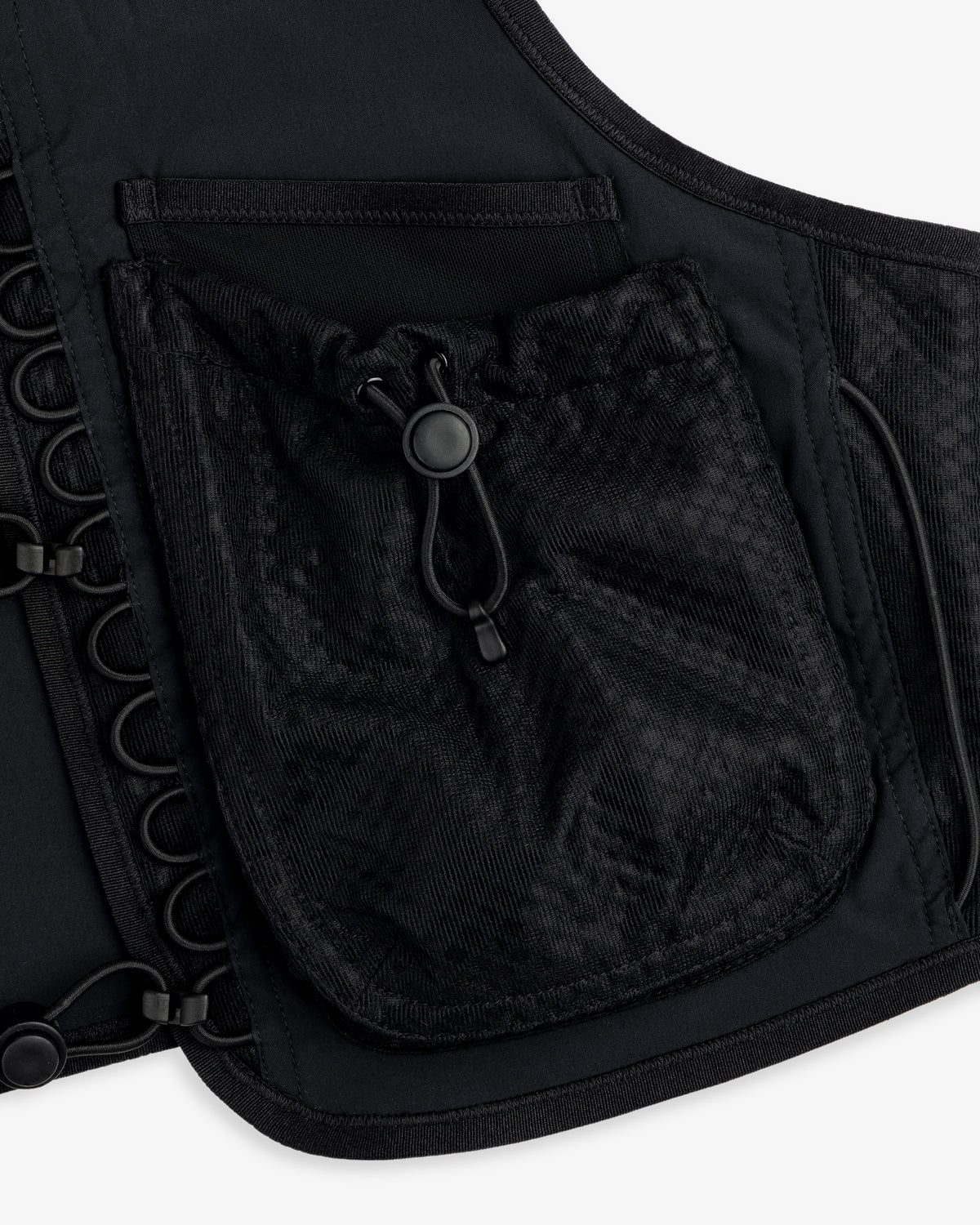 Close-up of the ALD / New Balance Hydrovest, a black vest with a mesh pocket, drawstring, and grommet details.