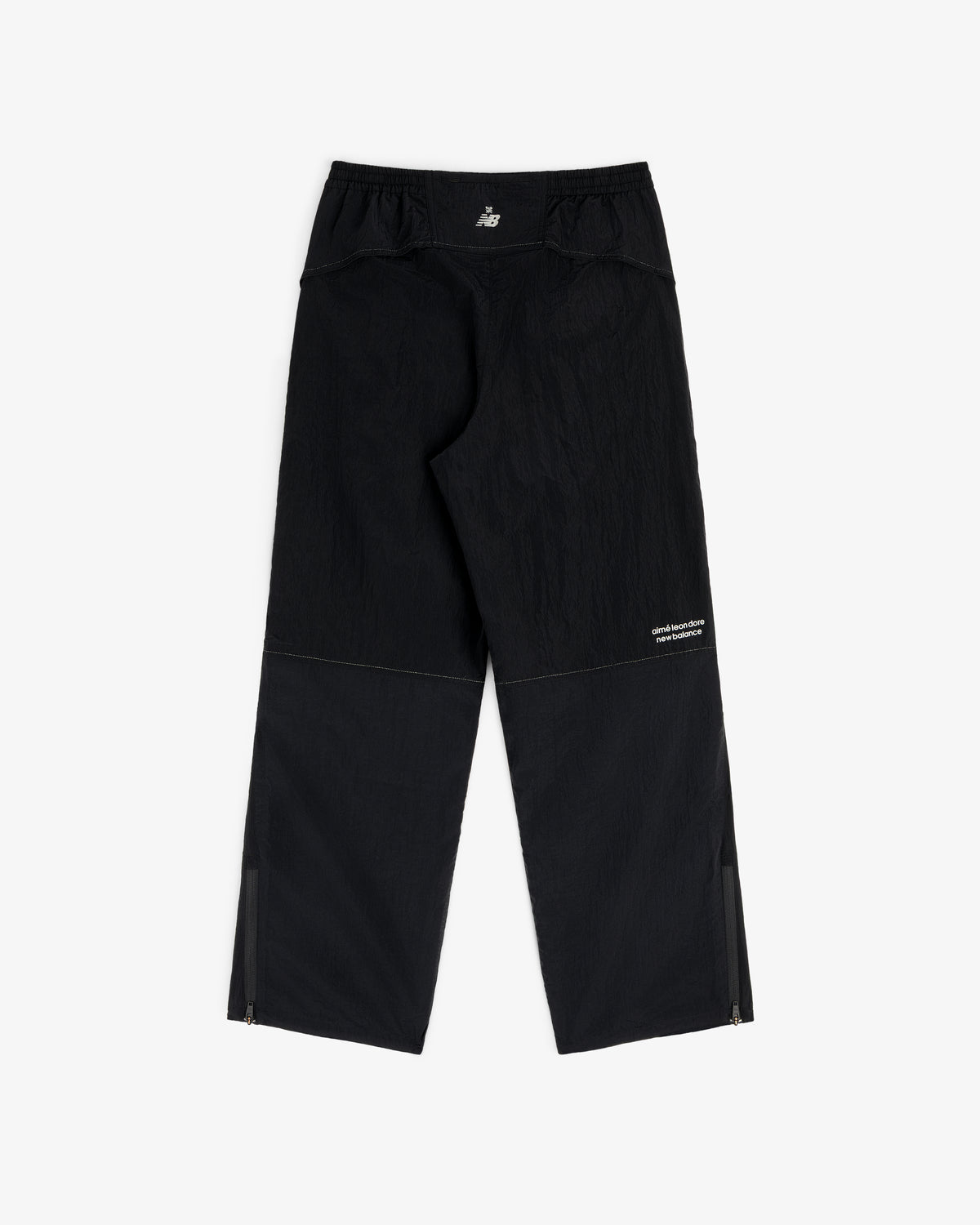 ALD / New Balance Lightweight Nylon Warmup Pant, black with ankle zippers and small white logo, displayed flat.