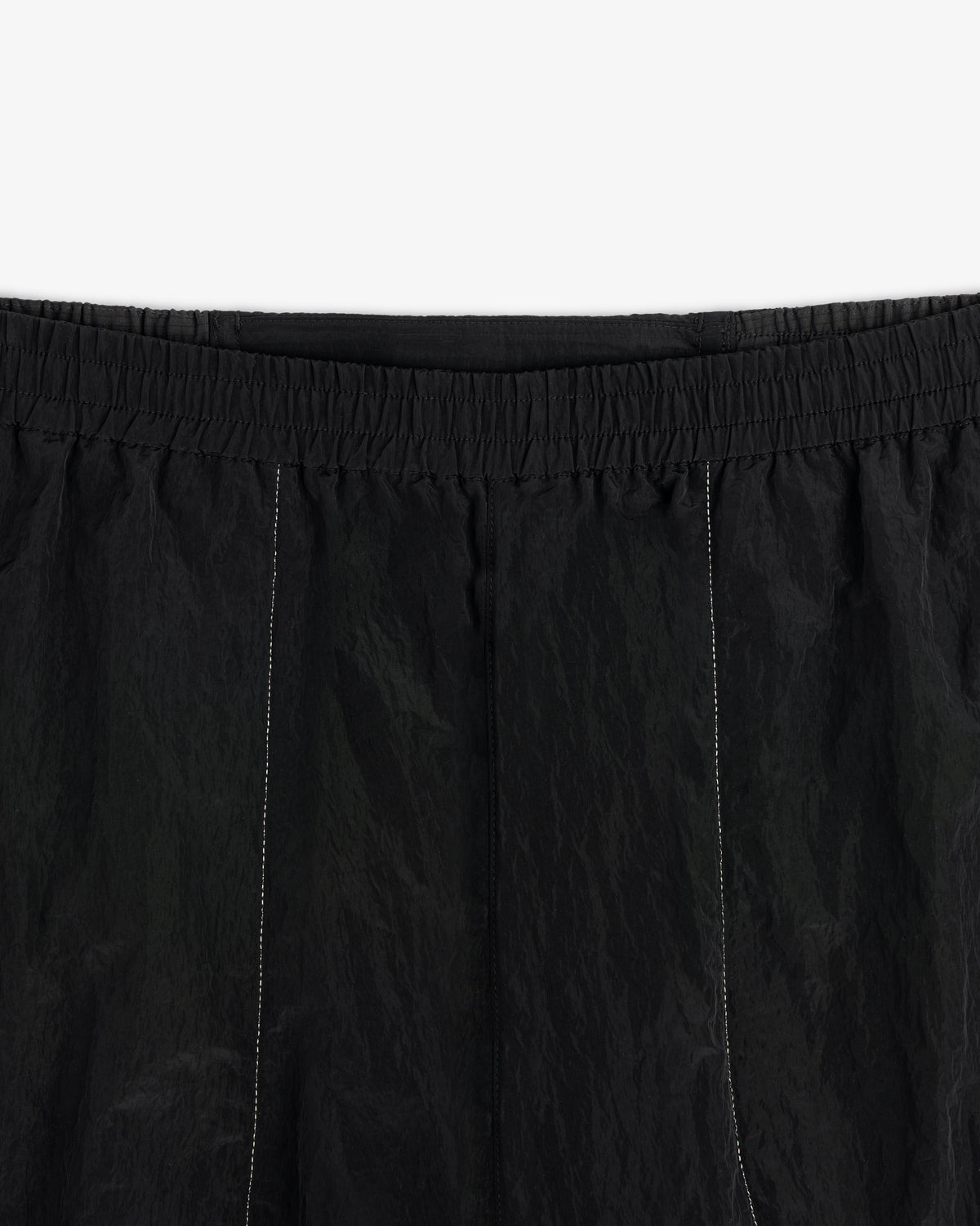 Close-up of ALD / New Balance Lightweight Nylon Warmup Pant with elastic waistband and subtle vertical stitching.