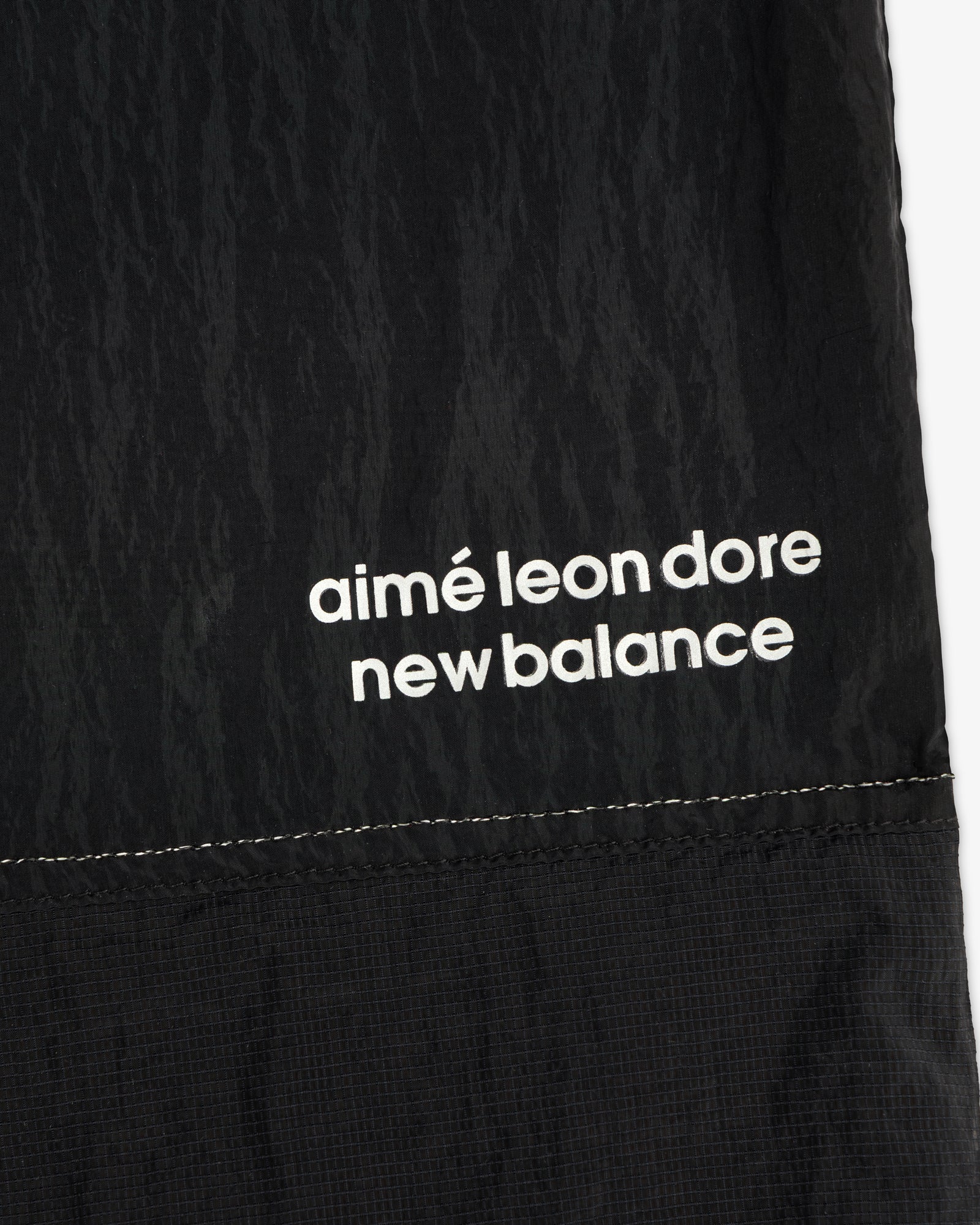 Black nylon ALD / New Balance Lightweight Warmup Pant with white branding and visible stitching at the hem.