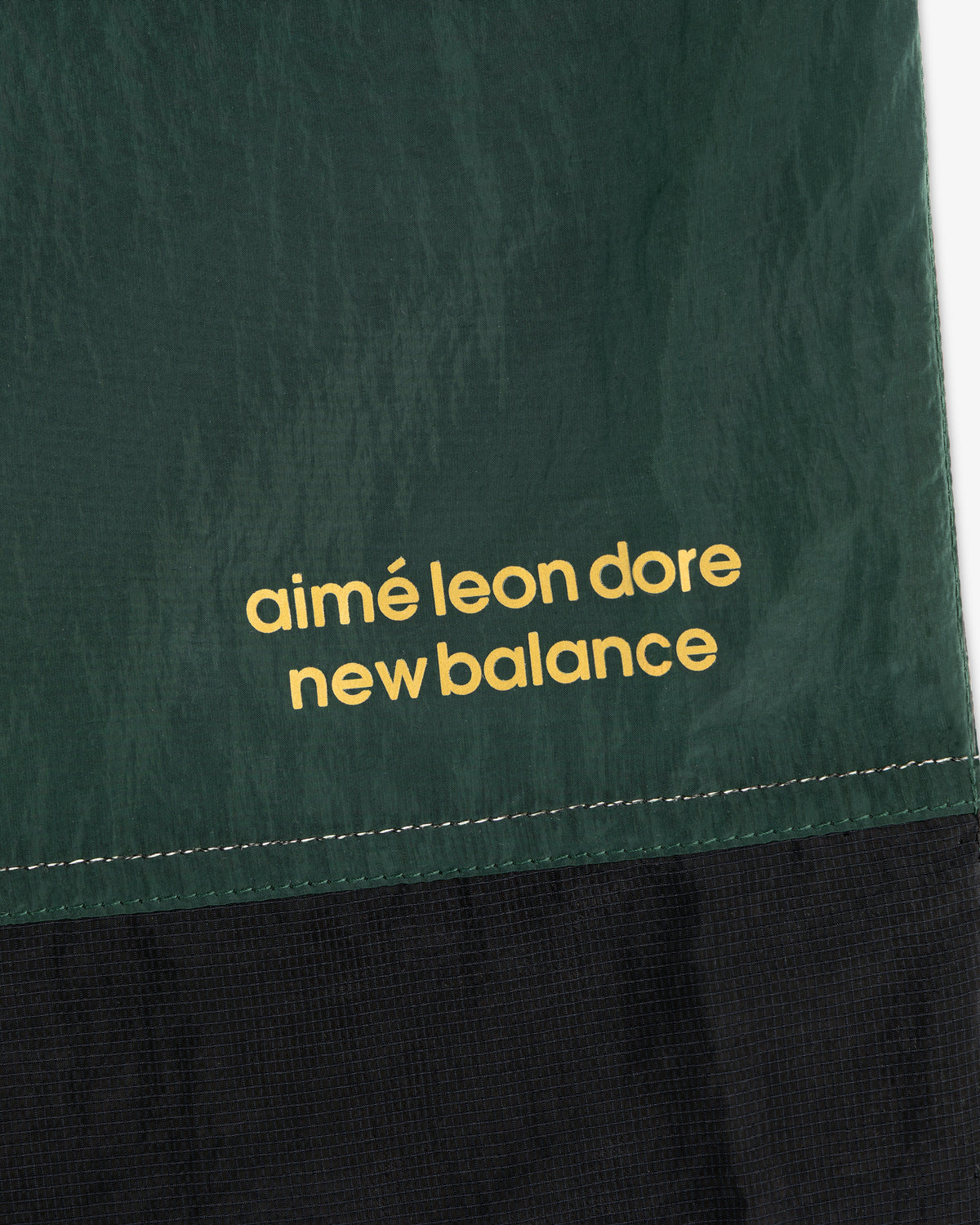 Green and black ALD / New Balance Lightweight Nylon Warmup Pant with yellow branding printed on fabric.