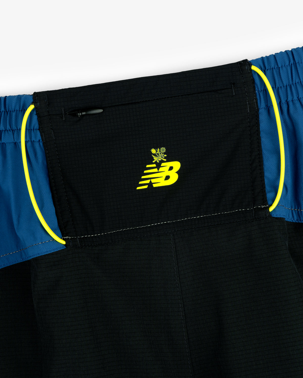 Close-up of the ALD / New Balance Performance Lightweight Running Short with a black/blue waistband and neon yellow accents.