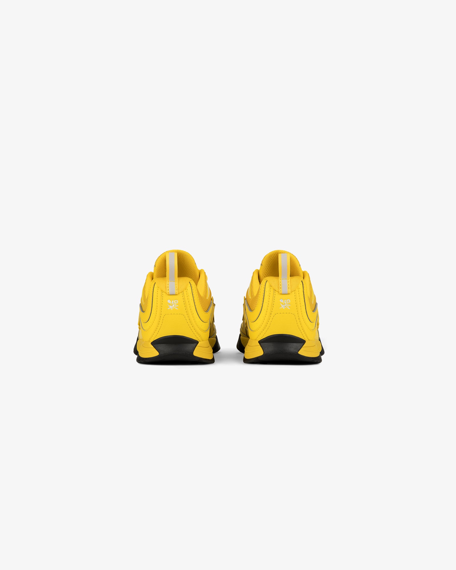 Back view of ALD / New Balance RC56 yellow athletic shoes with black soles on a white background.