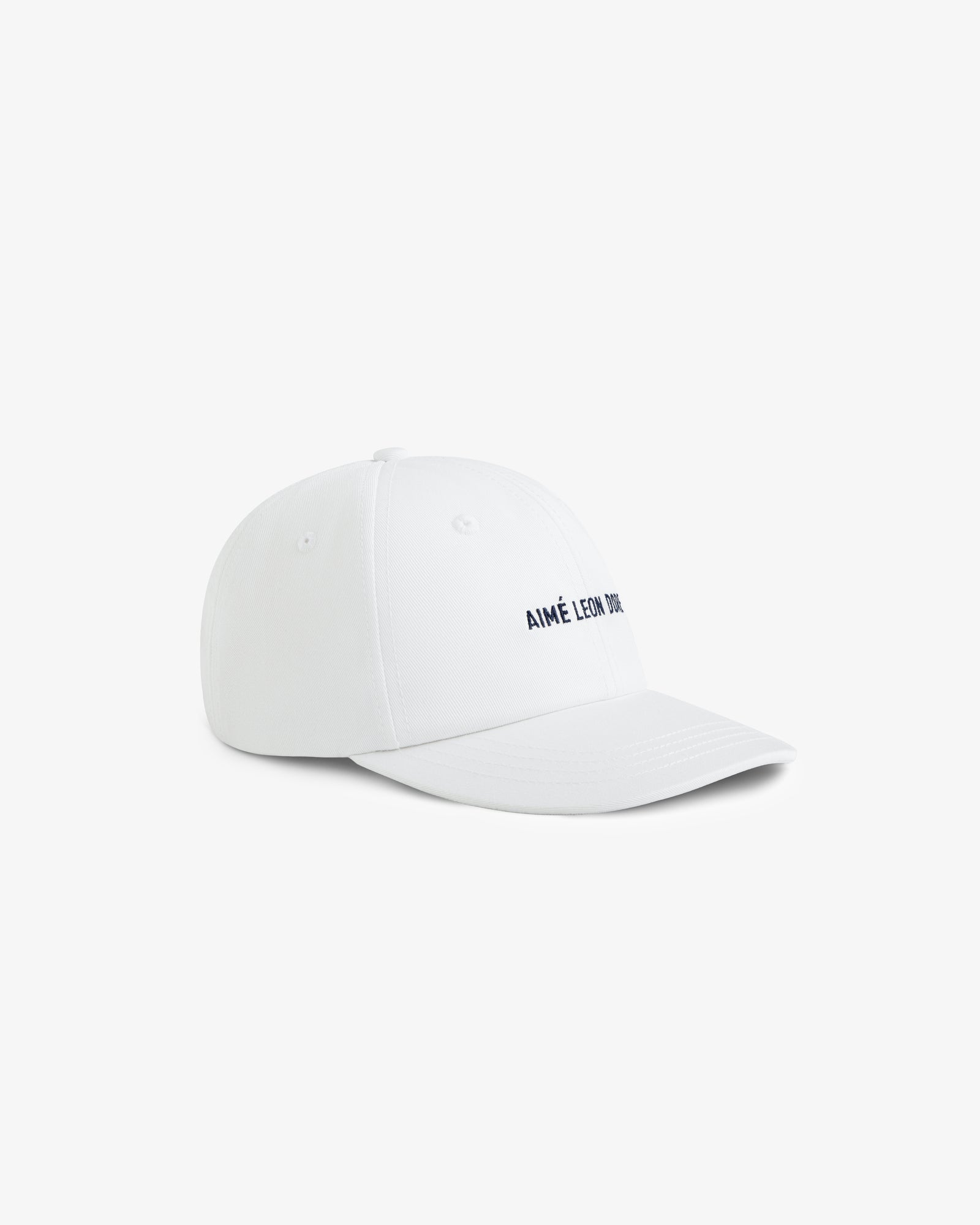 Core Logo Hat in white with small black AIMÉ LEON DORE text on the front, shown at an angle on a white background.