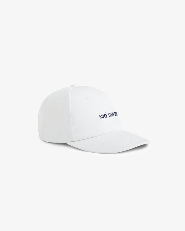 Core Logo Hat in white with small black AIMÉ LEON DORE text on the front, shown at an angle on a white background.