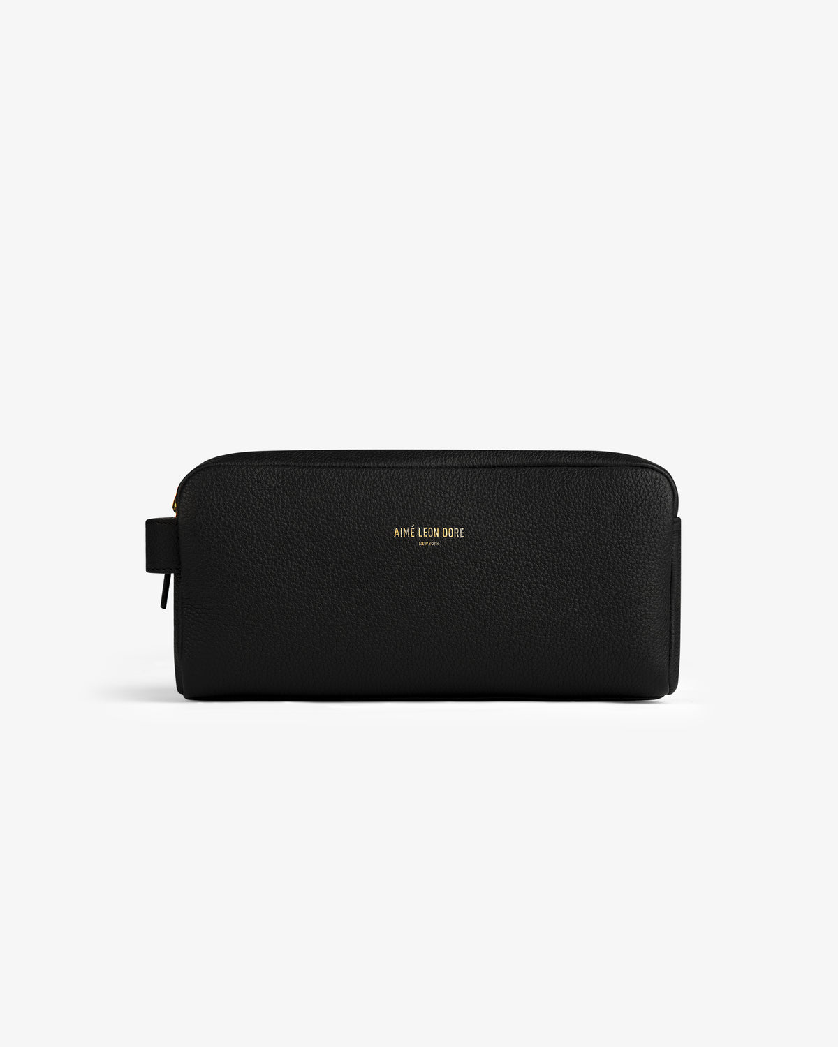 The Leather Traveler Kit is a black leather zippered toiletry bag with a side handle and gold AIMÉ LEON DORE branding.