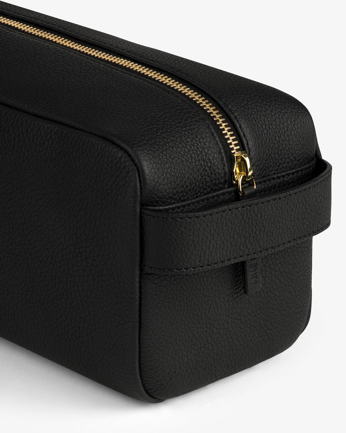 The Leather Traveler Kit—a black leather toiletry bag with a gold zipper and side handle—on a white background.