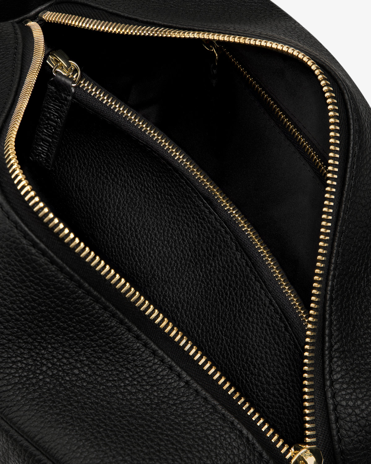 Close-up of the Leather Traveler Kit, open to reveal a spacious interior and an inner zippered pocket.