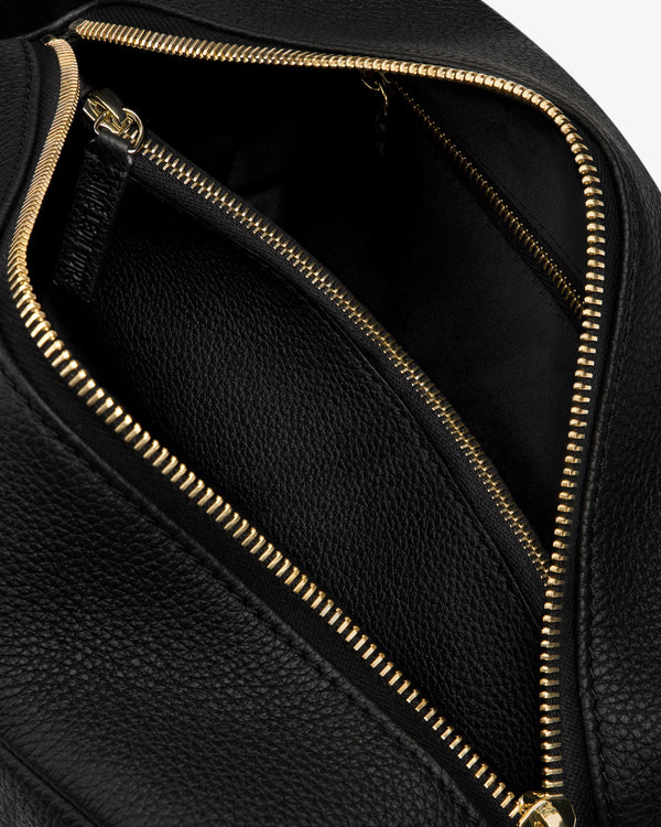 Close-up of the Leather Traveler Kit, open to reveal a spacious interior and an inner zippered pocket.