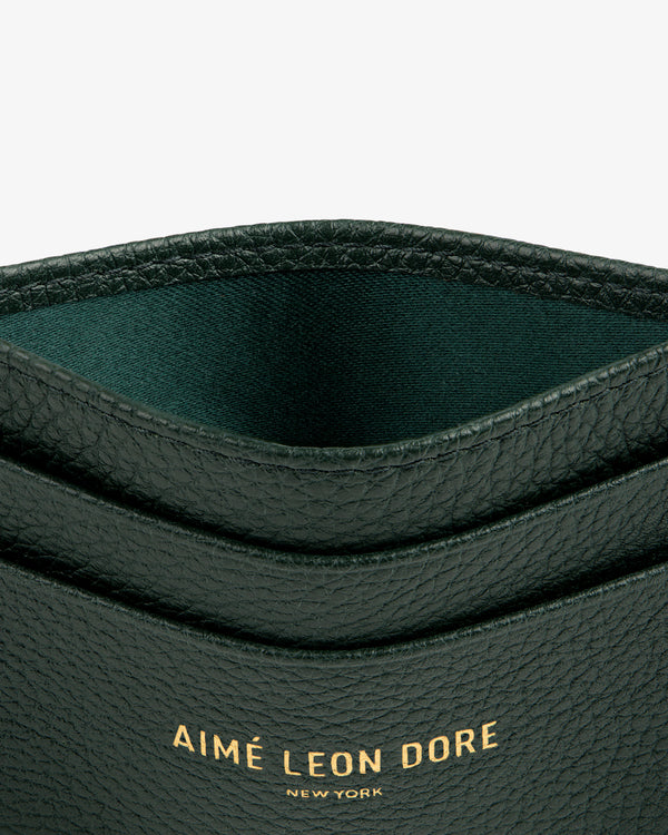 Close-up of a textured black Leather Card Holder with AIMÉ LEON DORE NEW YORK embossed in gold.