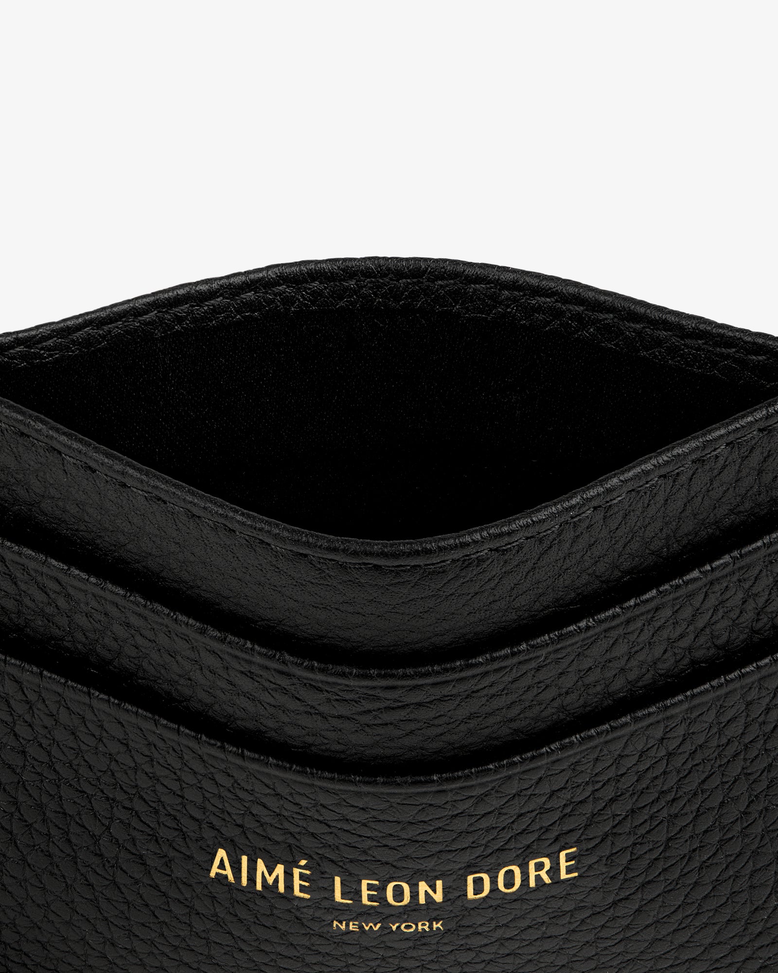 Leather Card Holder in black with gold AIMÉ LEON DORE NEW YORK text embossed on the front.