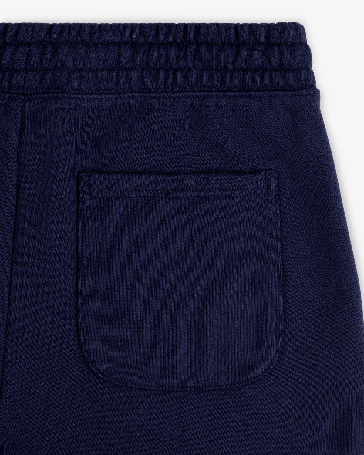 Close-up of back pocket and waistband on Unisphere Sweatpants in navy blue, highlighting visible stitching detail.