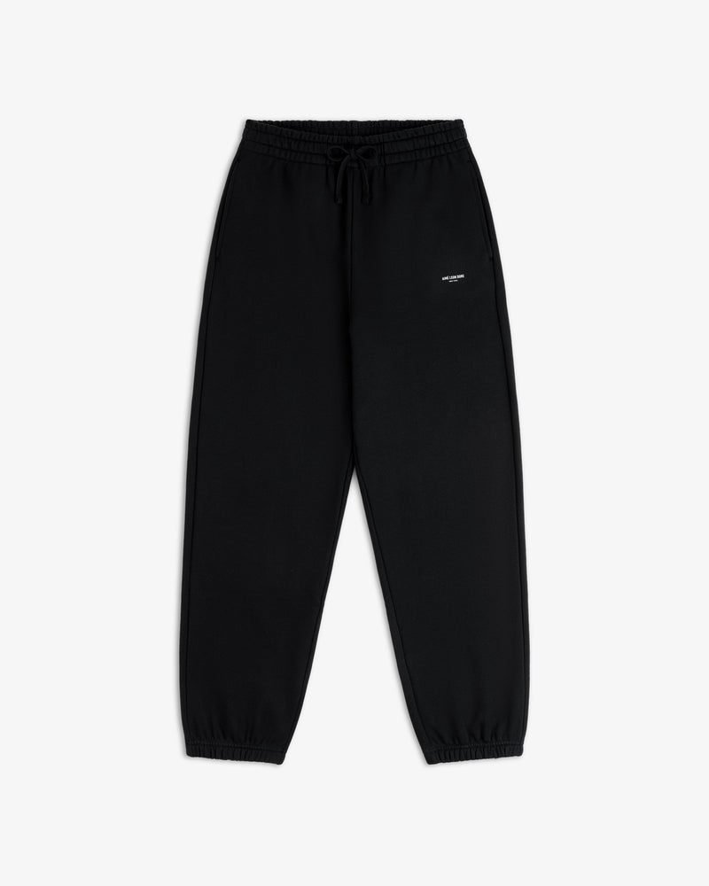 Micro Logo Sweatpants: black, elastic waist, drawstring, cuffed ankles, small white logo on left thigh.