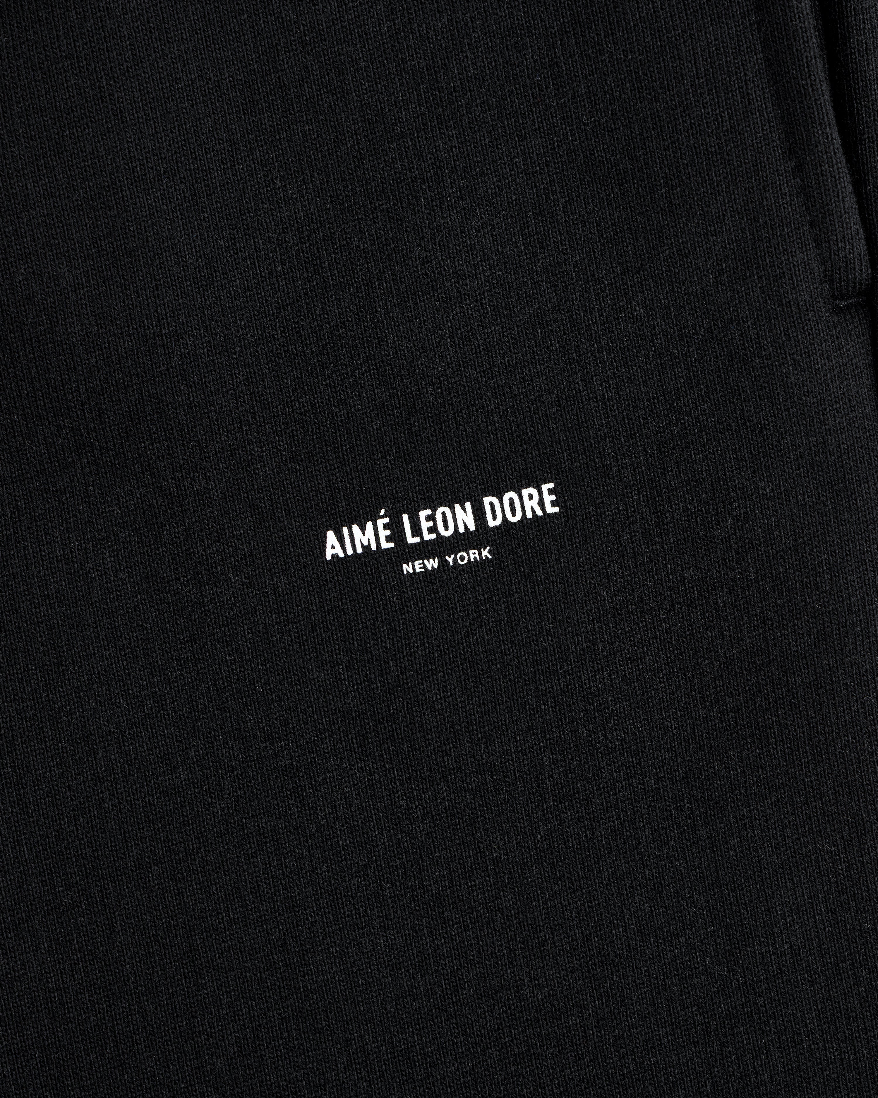 Close-up of black Micro Logo Sweatpants with AIMÉ LEON DORE NEW YORK printed in small white letters.