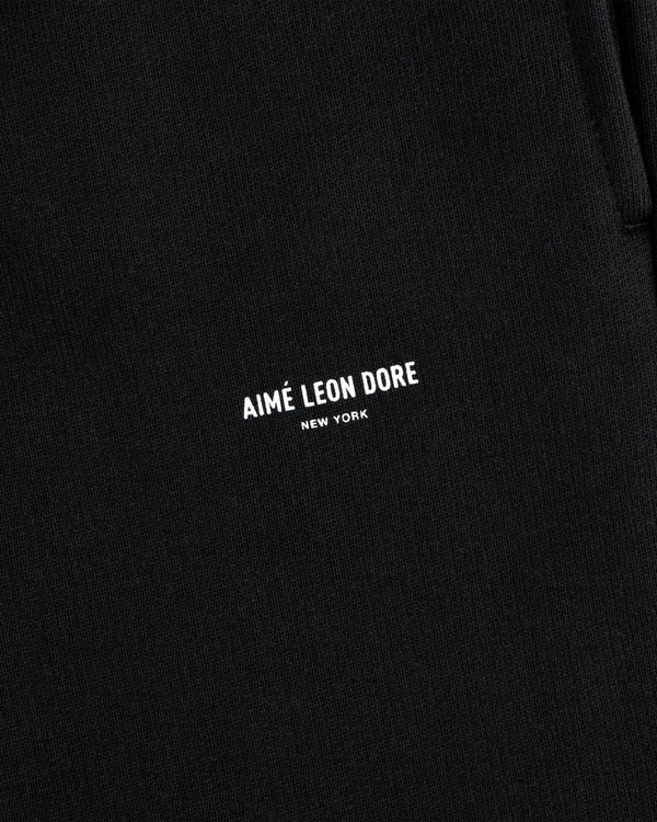 Close-up of black Micro Logo Sweatpants with AIMÉ LEON DORE NEW YORK printed in small white letters.