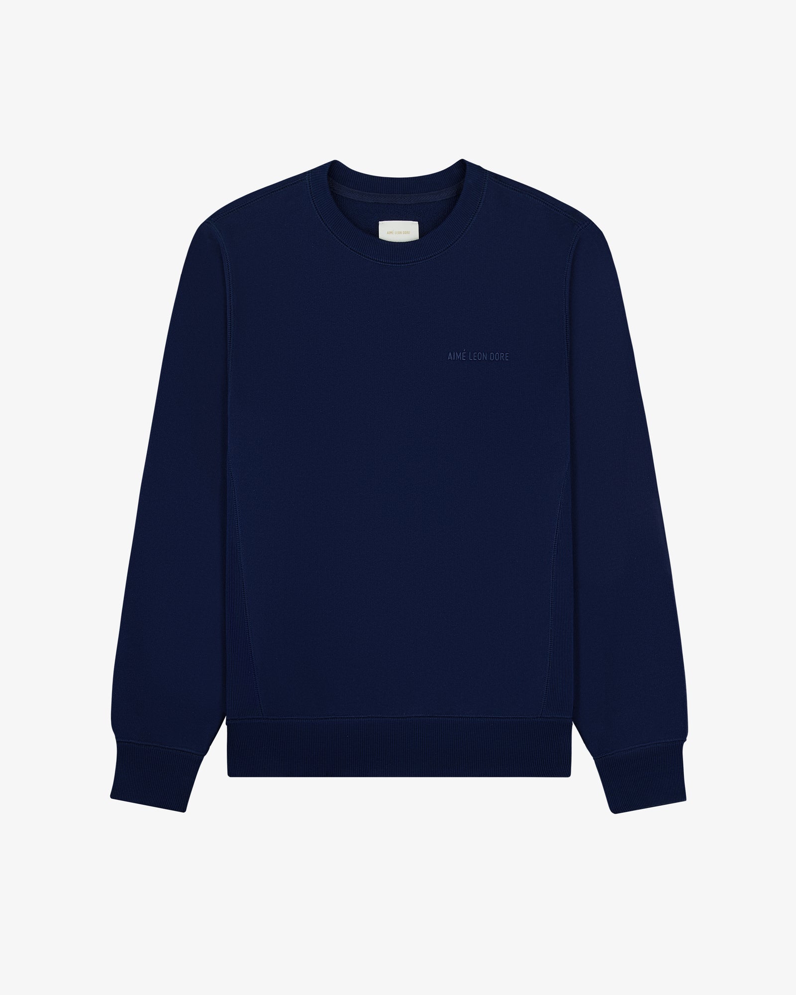 The Tonal Logo Crewneck Sweatshirt is navy, long-sleeved, with ribbed cuffs and a subtle chest logo.