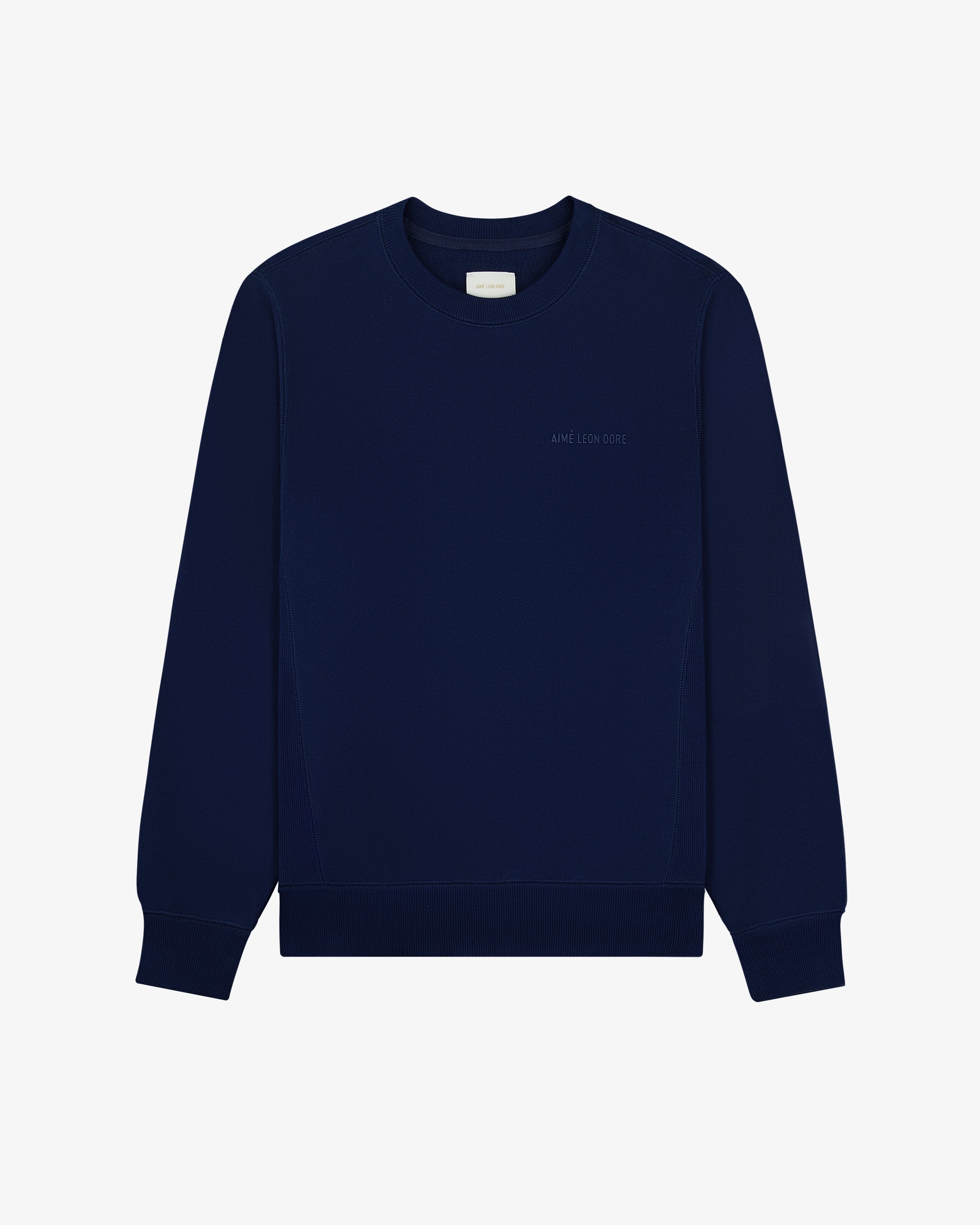 The Tonal Logo Crewneck Sweatshirt is navy, long-sleeved, with ribbed cuffs and a subtle chest logo.