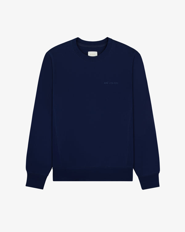 The Tonal Logo Crewneck Sweatshirt is navy, long-sleeved, with ribbed cuffs and a subtle chest logo.