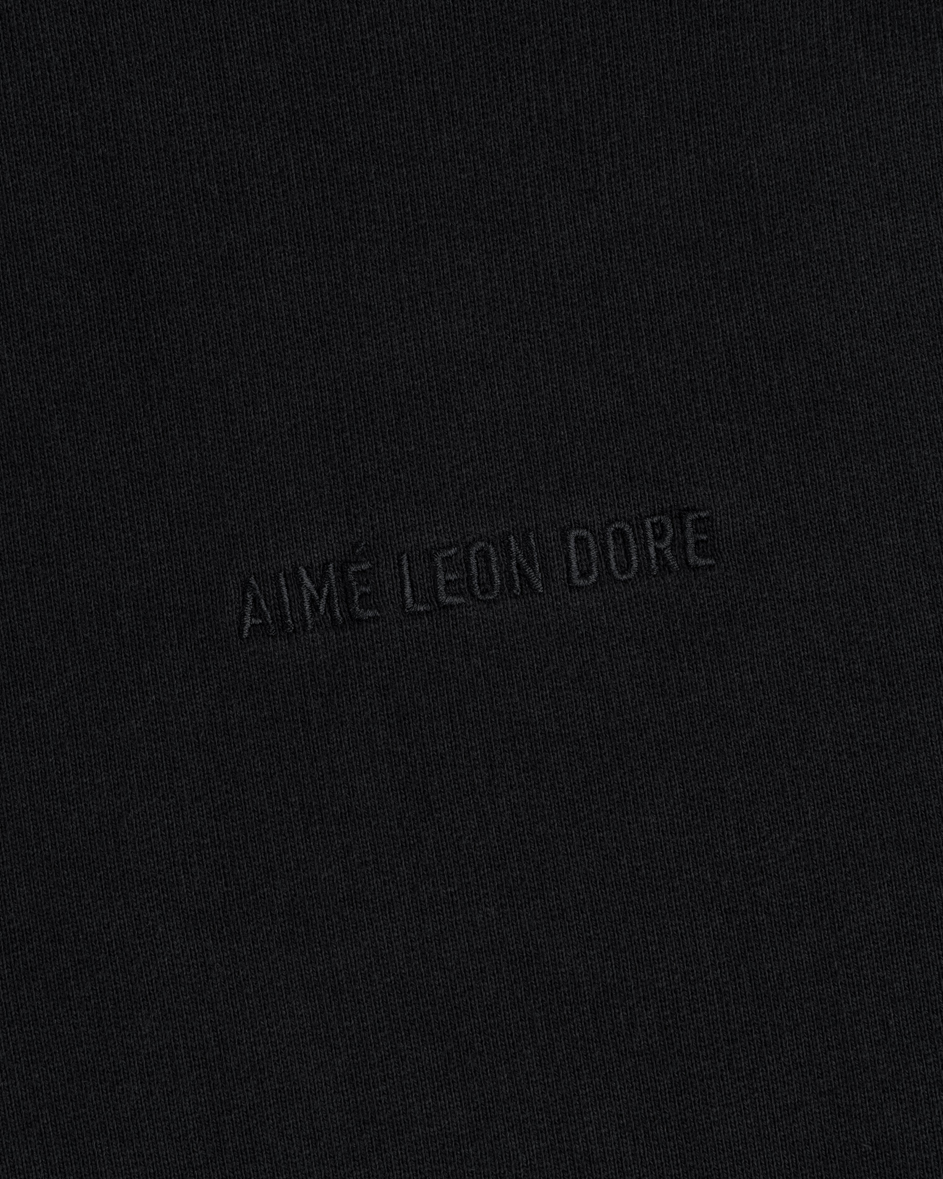 Close-up of black Tonal Logo Crewneck Sweatshirt with "AIME LEON DORE" embroidered in matching black thread.