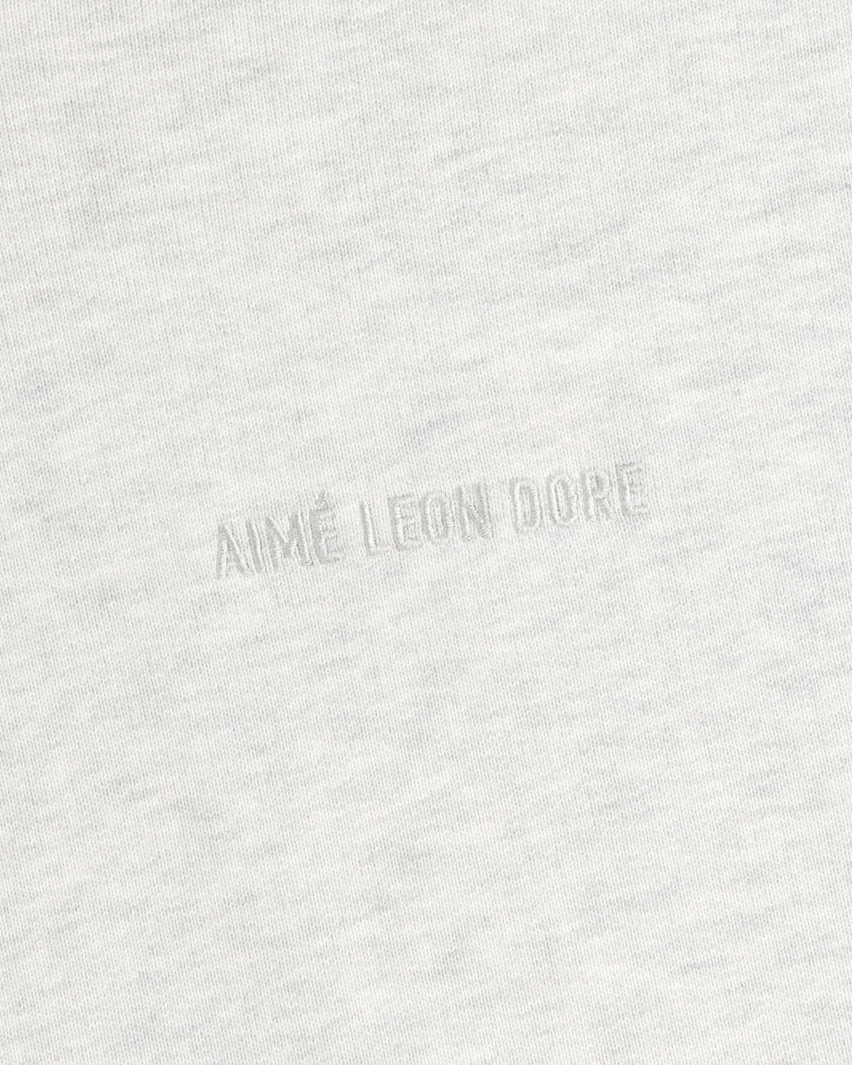 Close-up of Tonal Logo Crewneck Sweatshirt in light gray with AIMÉ LEON DORE subtly embossed at the center.