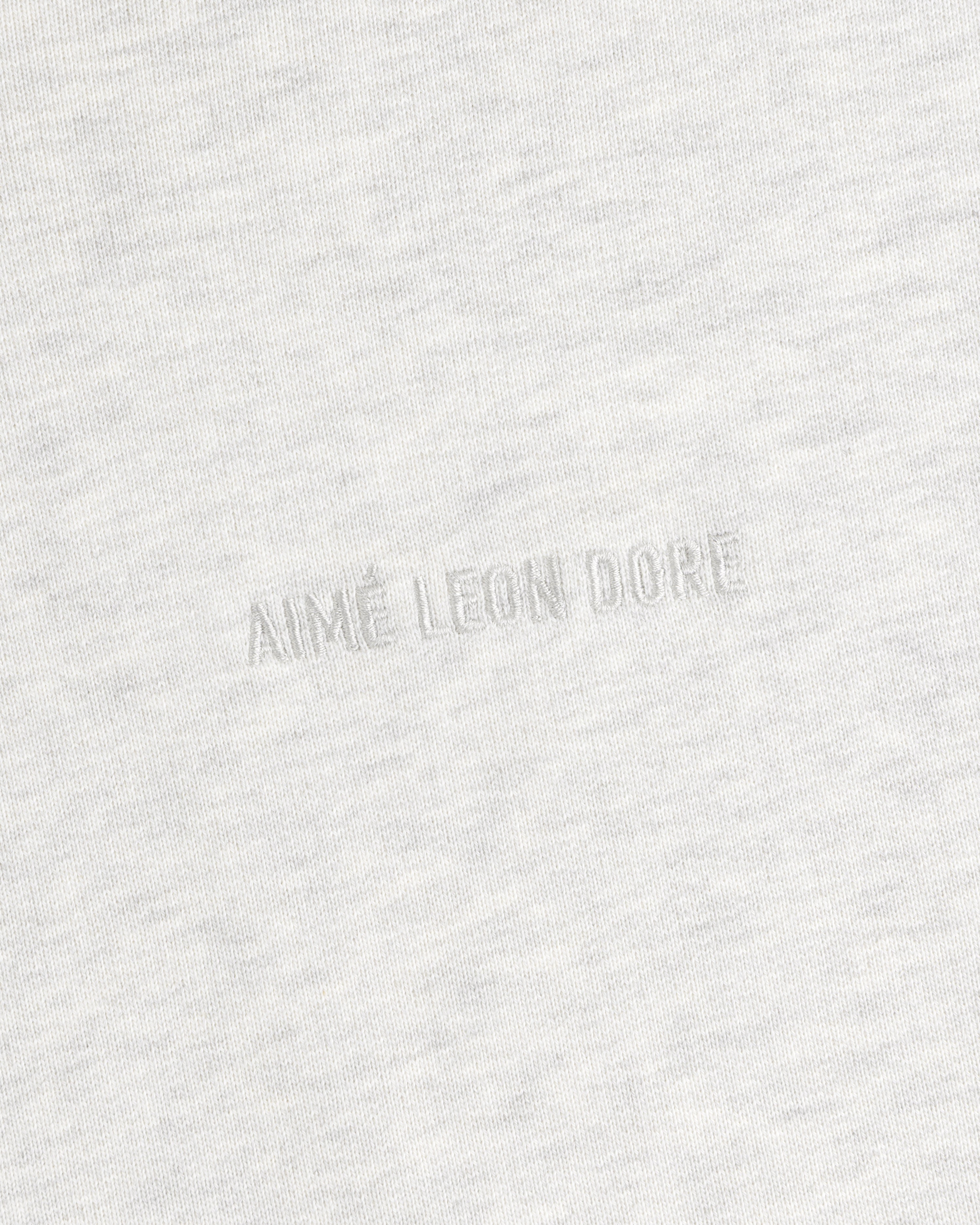Close-up of Tonal Logo Crewneck Sweatshirt in light gray with AIMÉ LEON DORE subtly embossed at the center.